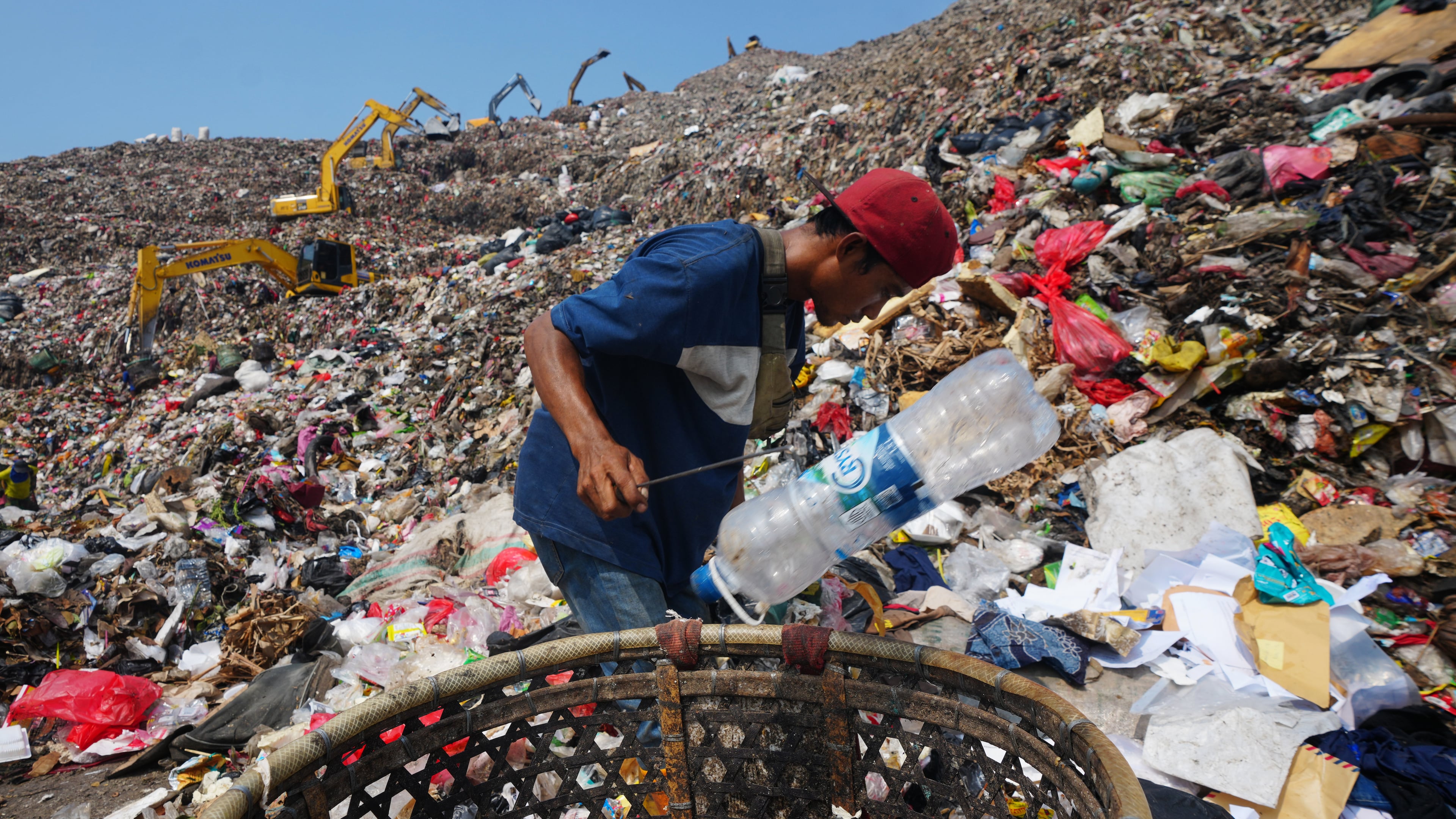 Komaruddin, a waste picker, looks for recyclable items in a pile of garbage at the Bantargebang landfill on the outskirts of Jakarta, Indonesia, Monday, July 6, 2026. (AP Photo/Tatan Syuflana)