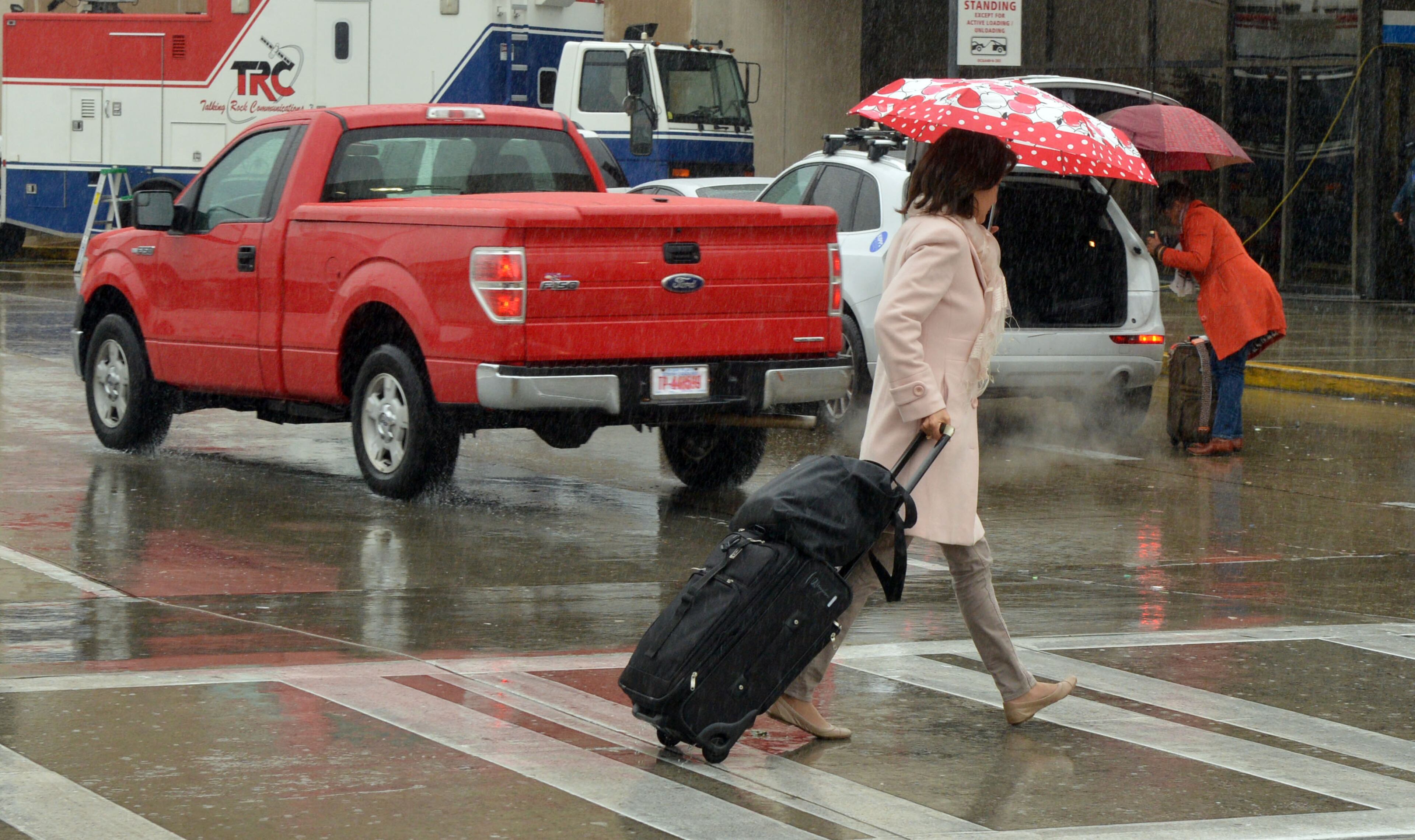 Travelers make their way into Hartsfield Jackson International Airport to flights Tuesday, November 26, 2013. A steady rain, which is predicted to worsen later in the day, was not causing flight delays at mid-day. KENT D. JOHNSON / KDJOHNSON@AJC.COM