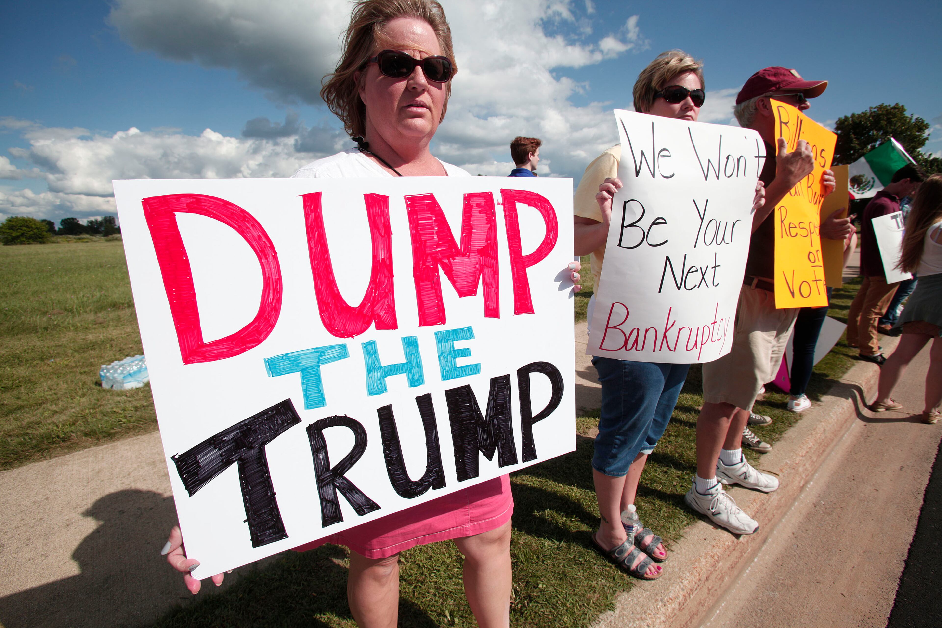 BIRCH RUN, MI - AUGUST 11: People protest the appearance of 2016 Republican presidential candidate Donald Trump at the venue where he will be delivering the keynote address at the Genesee and Saginaw Republican Party Lincoln Day Event August 11, 2015 in Birch Run, Michigan. This is Trump's first campaign event since his Republican debate last week. (Photo by Bill Pugliano/Getty Images)
