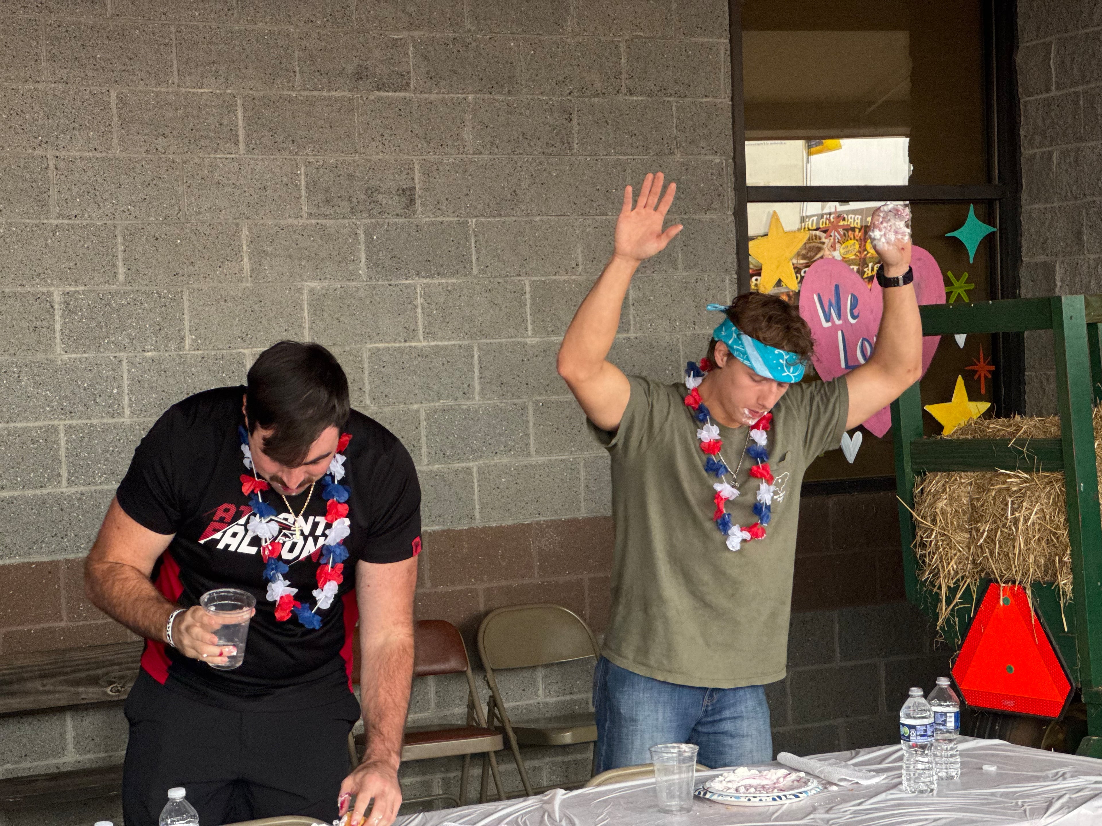 Dylan McLaughlin (left) and James Dean face off in a funnel cake eating contest on Oct. 5, 2025. (Caleb Groves/AJC)