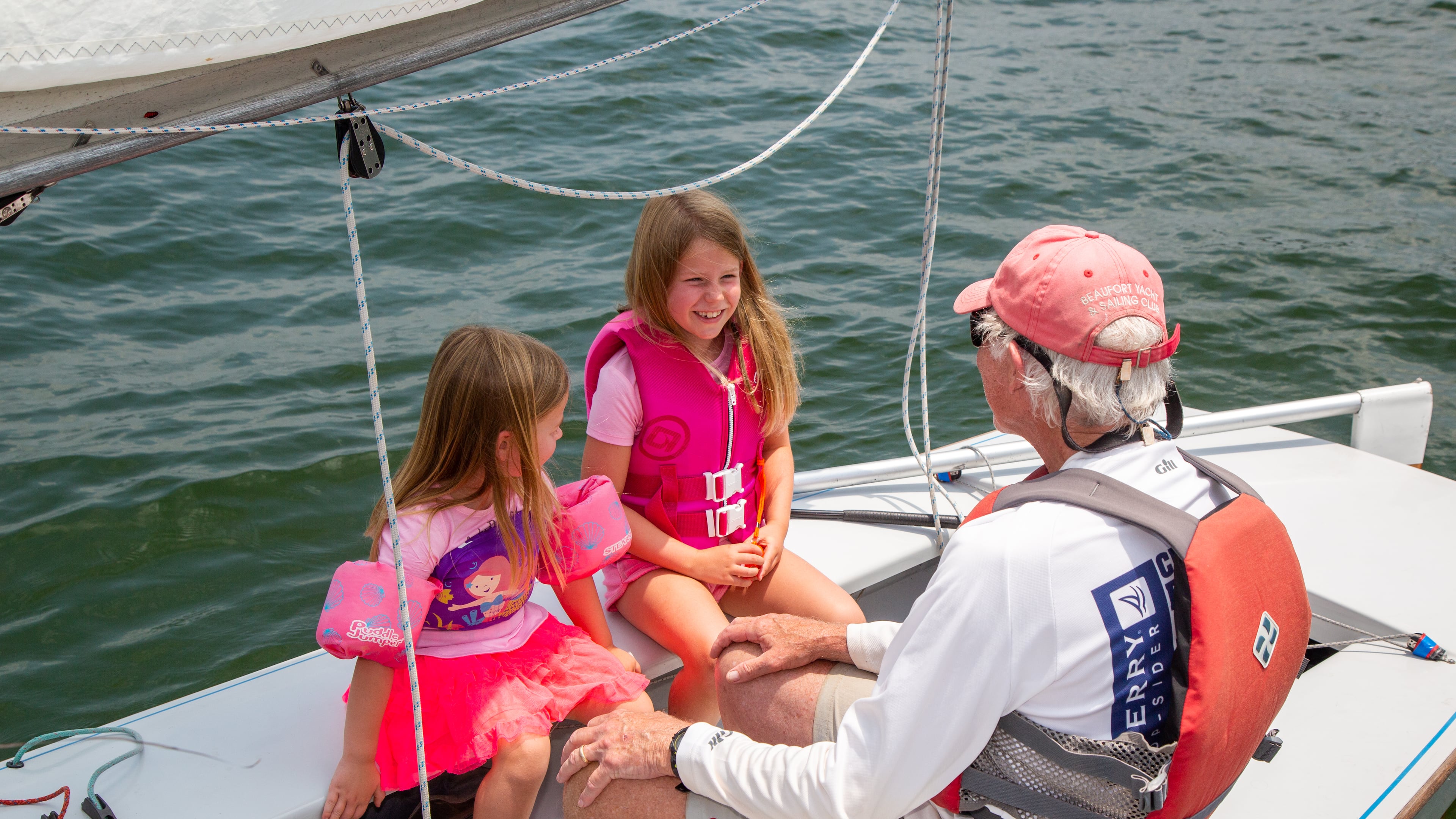 (left to right) Eva Muhlhausen (age 5) & her sister Ellen (7) talk with their grandfather John on his Snipe sailboat at the the Atlanta Yacht Club on Lake Allatoona. PHIL SKINNER FOR THE ATLANTA JOURNAL-CONSTITUTION.