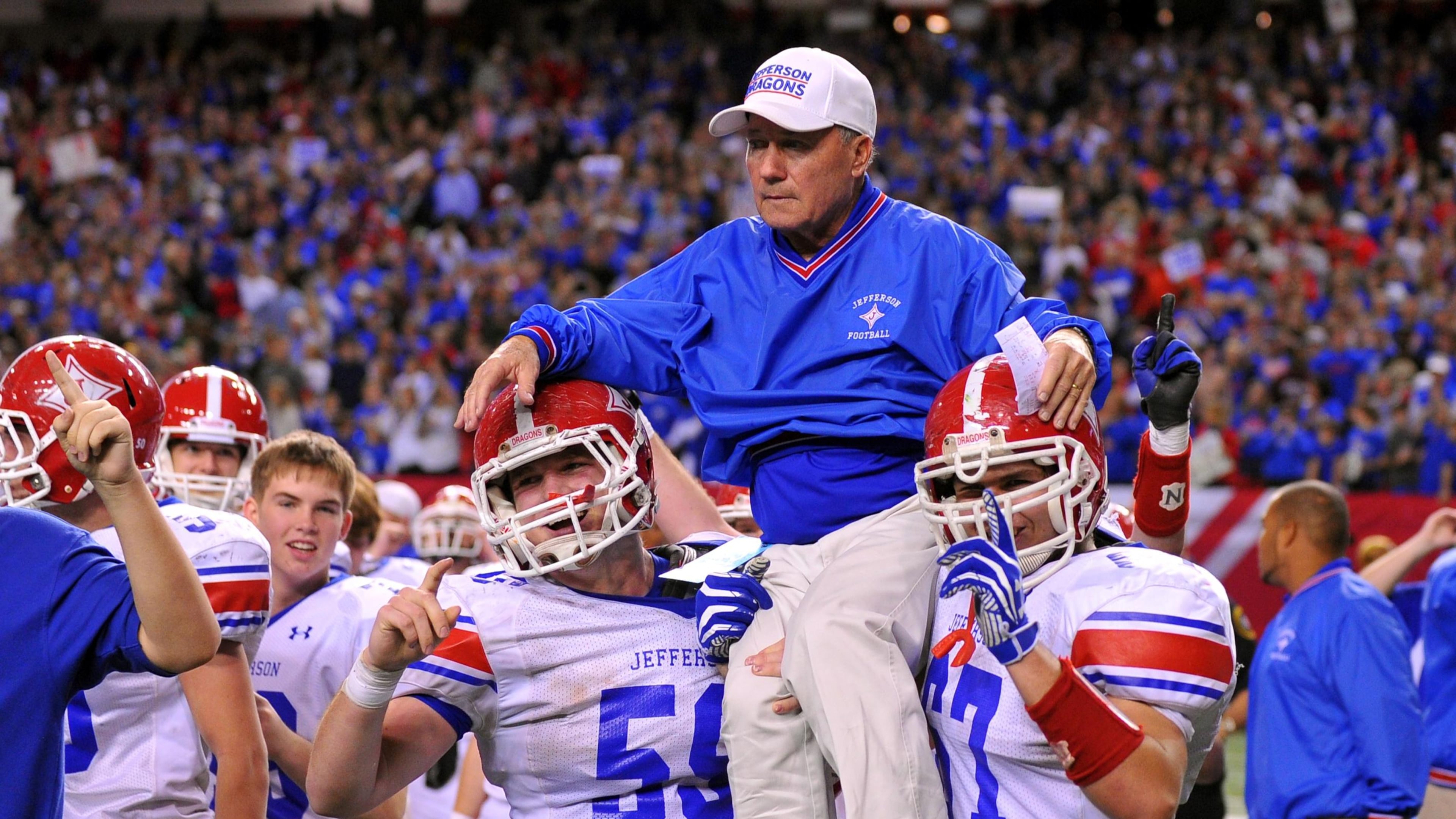 Jefferson head coach T. McFerrin is carried onto the field by Jordan Tyler (left) and Conner Nations.