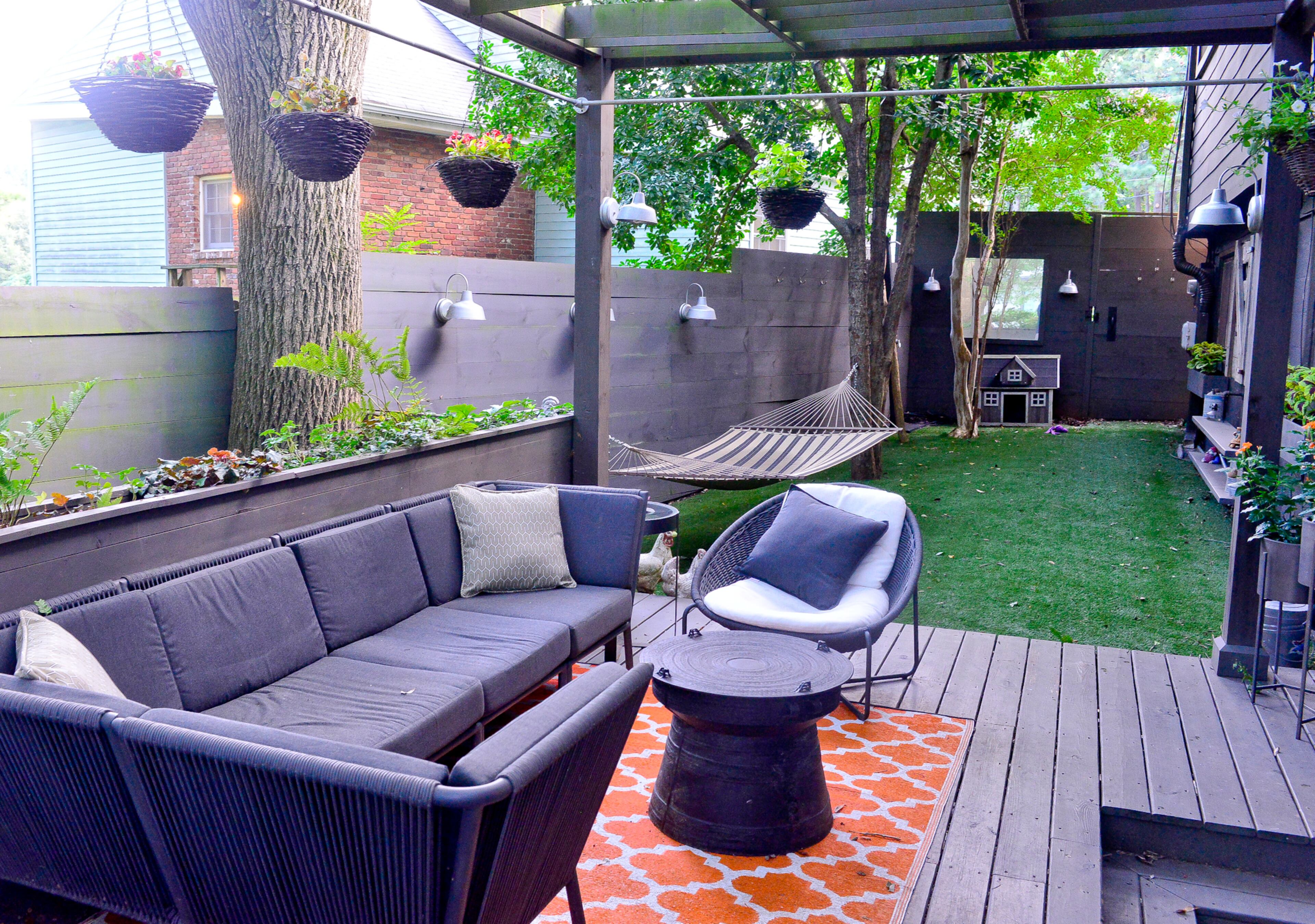 There's a mix of styles and seating options in another outdoor space, including the Morocco sectional in charcoal and oval lounge chair from Crate and Barrel. The pergola provides shading and a place to add hanging baskets near a built-in planter. Dogs Kerrigan and Fiona get to play in the "designer dog run" with faux grass.