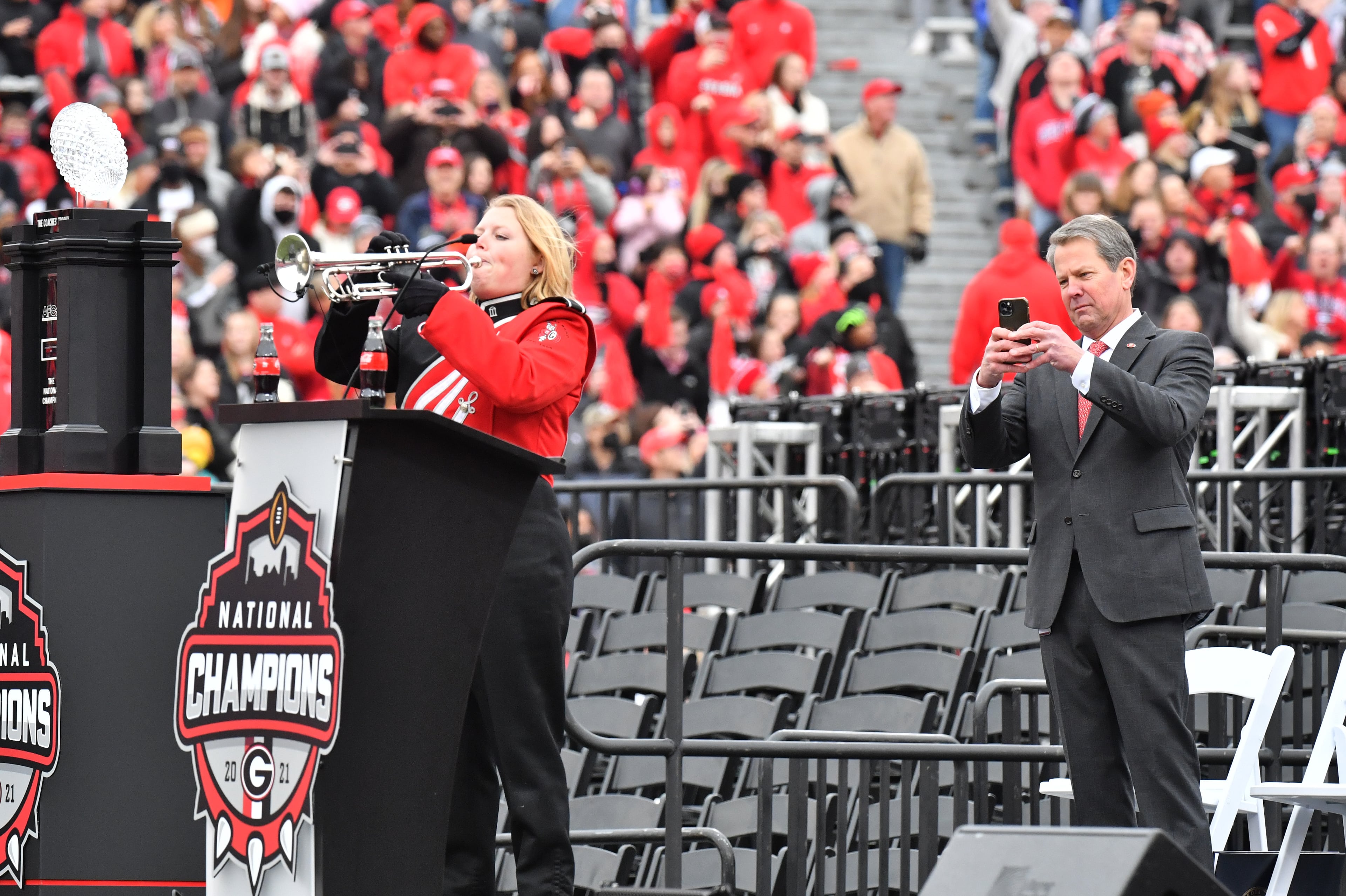 January 15, 2022 Athens - Governor Brian Kemp holds his iPhone as a lone trumpet player performs during the celebration of Georgia’s College Football Playoff national championship at Sanford Stadium in Athens on Saturday, January 15, 2022. Georgia captured the national championship, its first since the 1980 season, with a 33-18 victory over Alabama at Lucas Oil Stadium in Indianapolis. (Hyosub Shin / Hyosub.Shin@ajc.com)