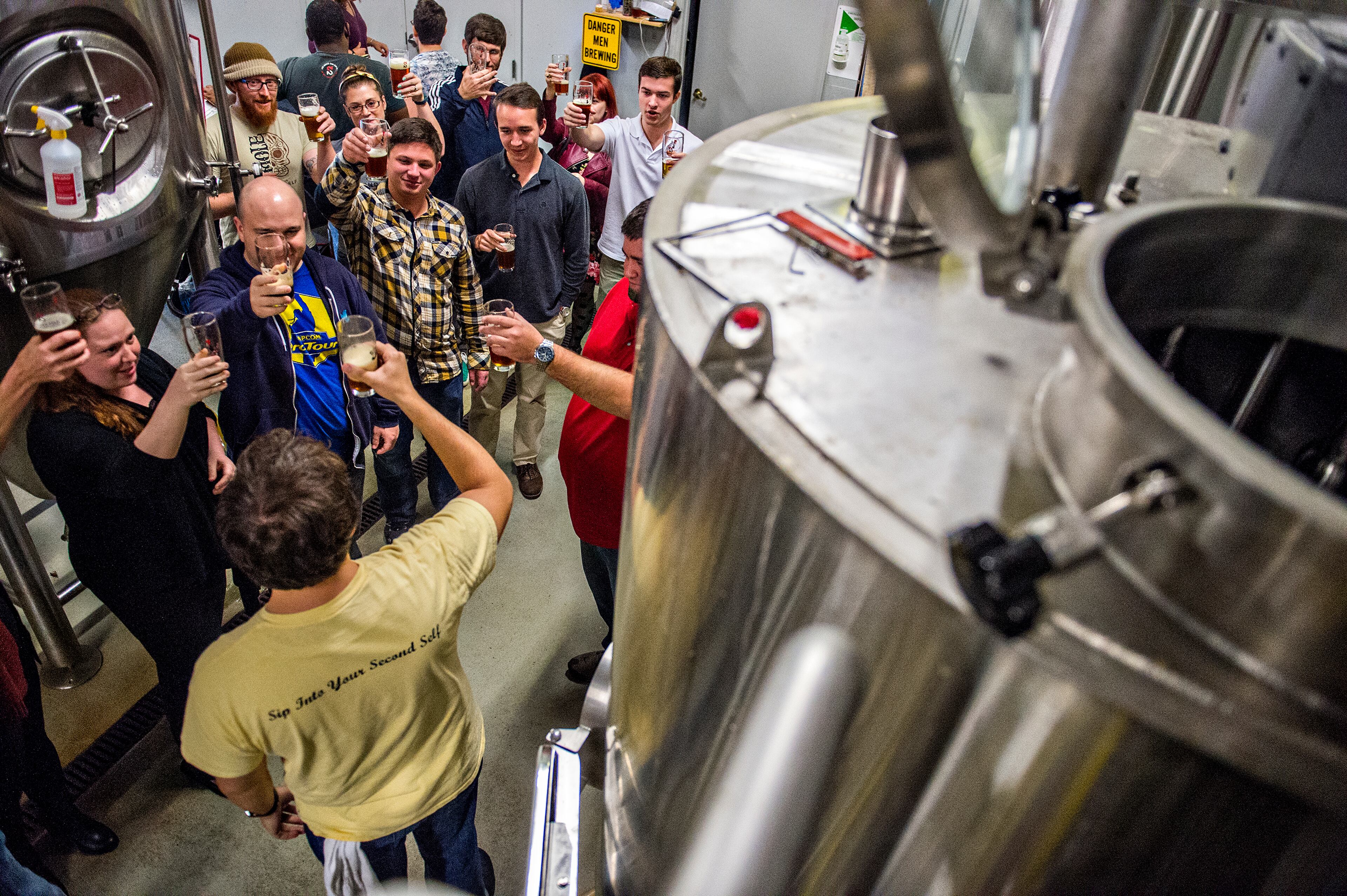 October 3, 2015 Atlanta - Ricki Sullivan (left), Mark Shields, Chris Price and Daniel Marsh raise their glasses with Jason Santamaria (bottom) as he leads a brewery tour during the Second Self Beer Company's one year anniversary celebration in Atlanta on Saturday, October 3, 2015. The brewery had 16 different beers to sample during the celebration. JONATHAN PHILLIPS / SPECIAL