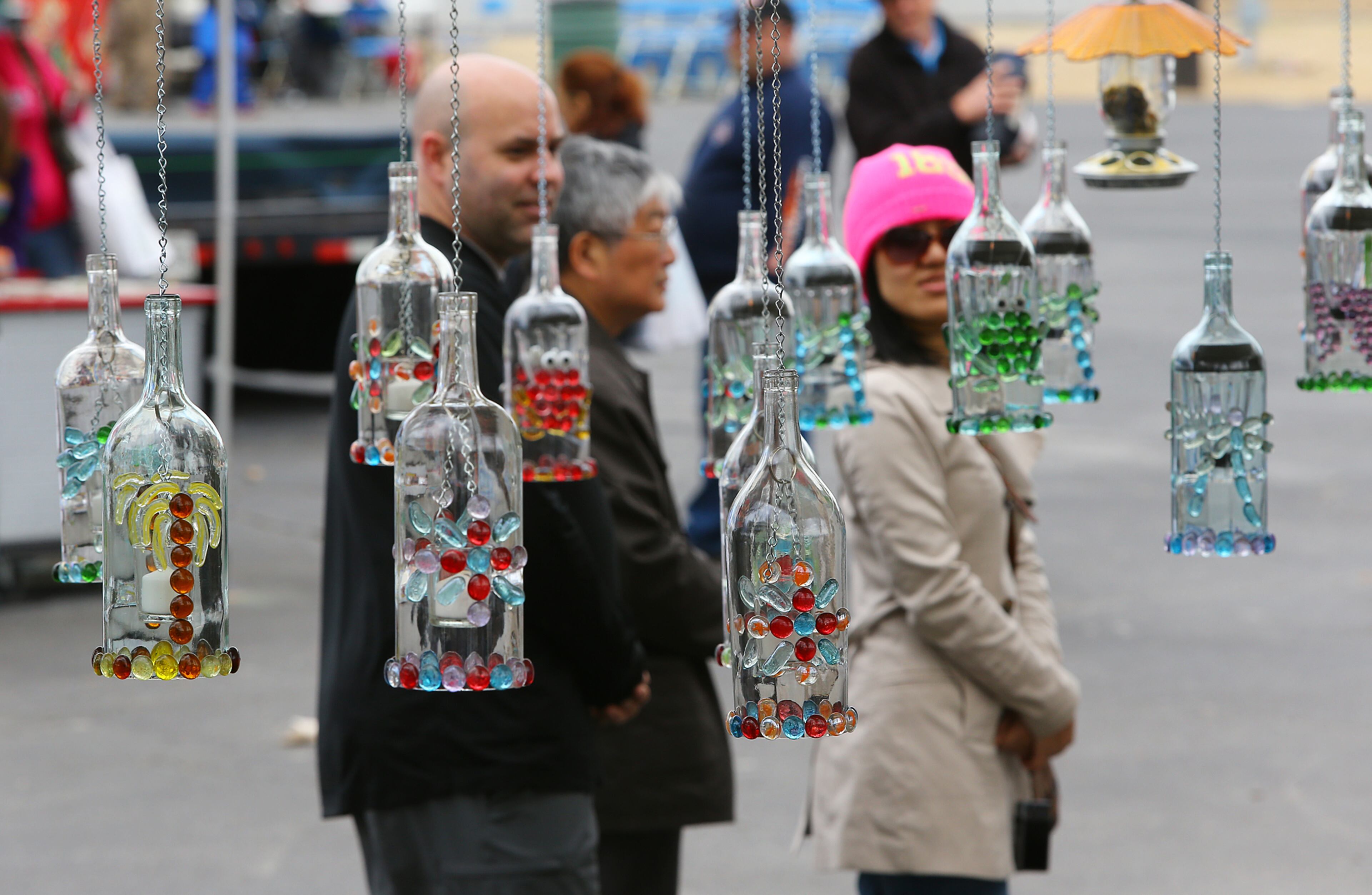 Visitors look over a display of candle bottles and wind chimes by vendor Melinda Nickelson at the 33rd Annual Conyers Cherry Blossom Festival on Sunday, March 23, 2014, in Conyers.