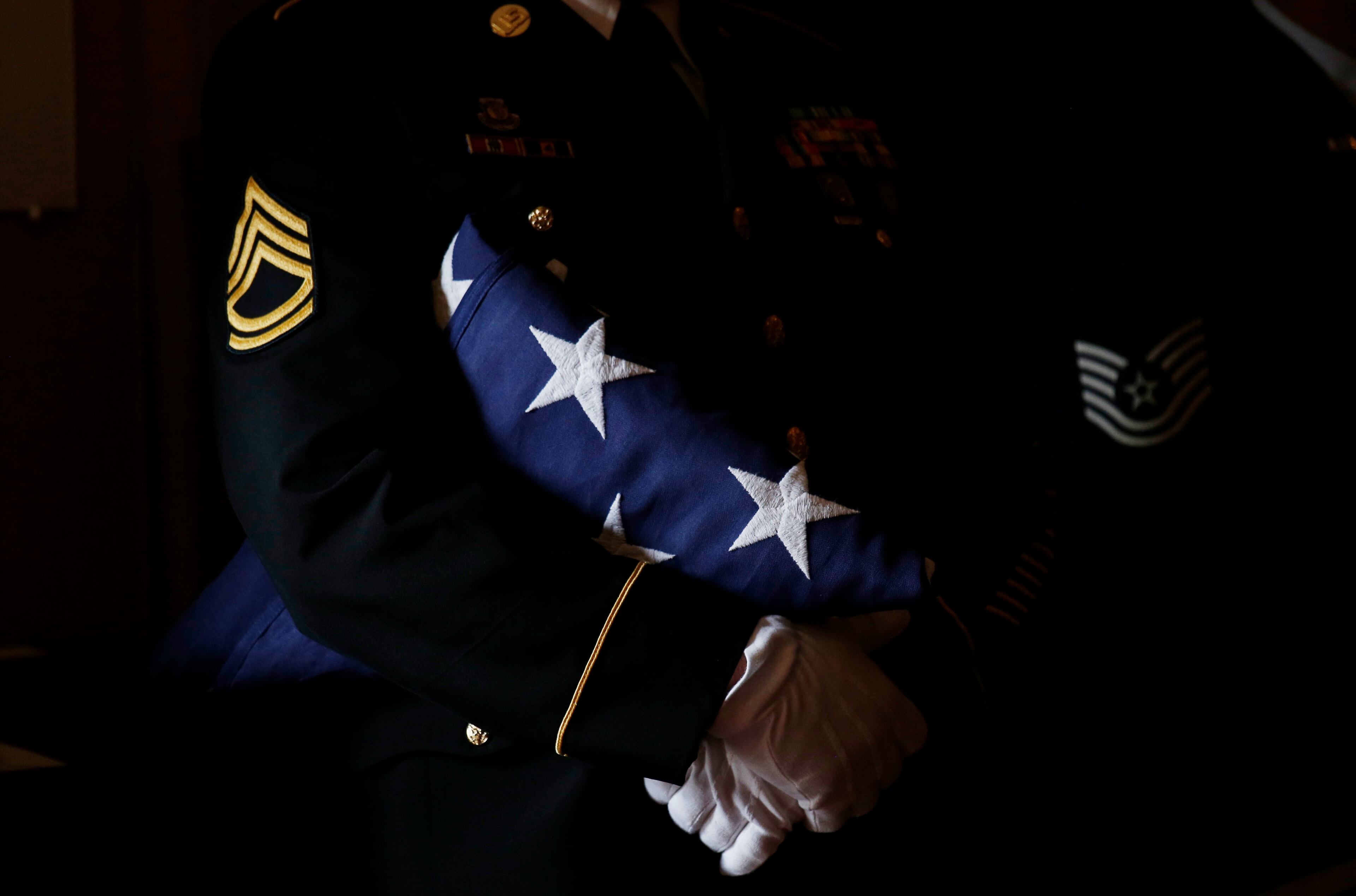 A member of the military honor guard holds an American flag from Vice President Joe Biden's son, Beau Biden's casket during funeral services, Saturday, June 6, 2015, at St. Anthony of Padua Church in Wilmington, Del. (Kevin Lamarque/Pool Photo via AP)