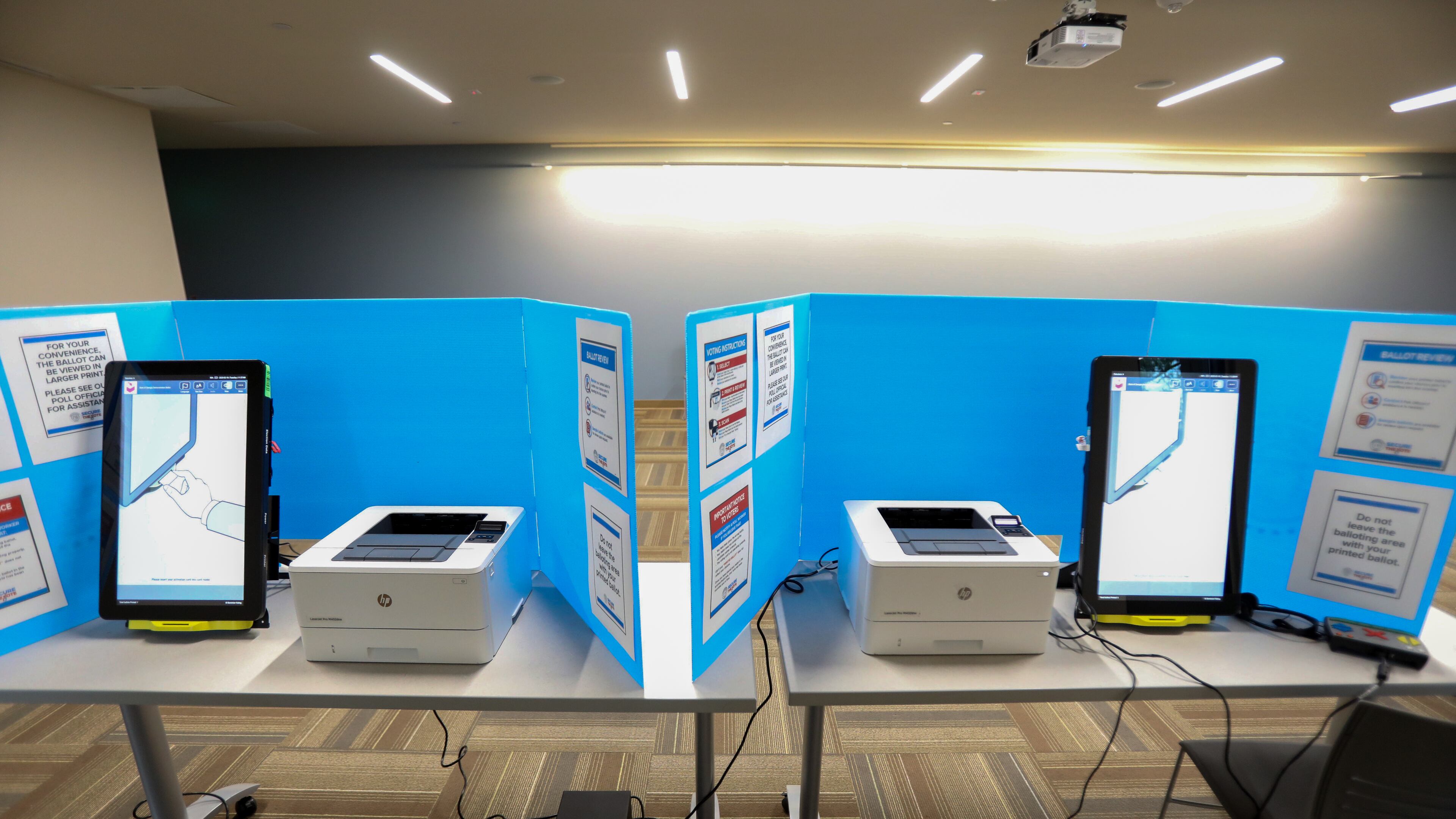 Two of the new Fulton County voting machines sit at the Sandy Springs Library on Tuesday Feb. 18, 2020. The new machines print the voter's selections on a paper ballot which is then scanned and the vote is cast.