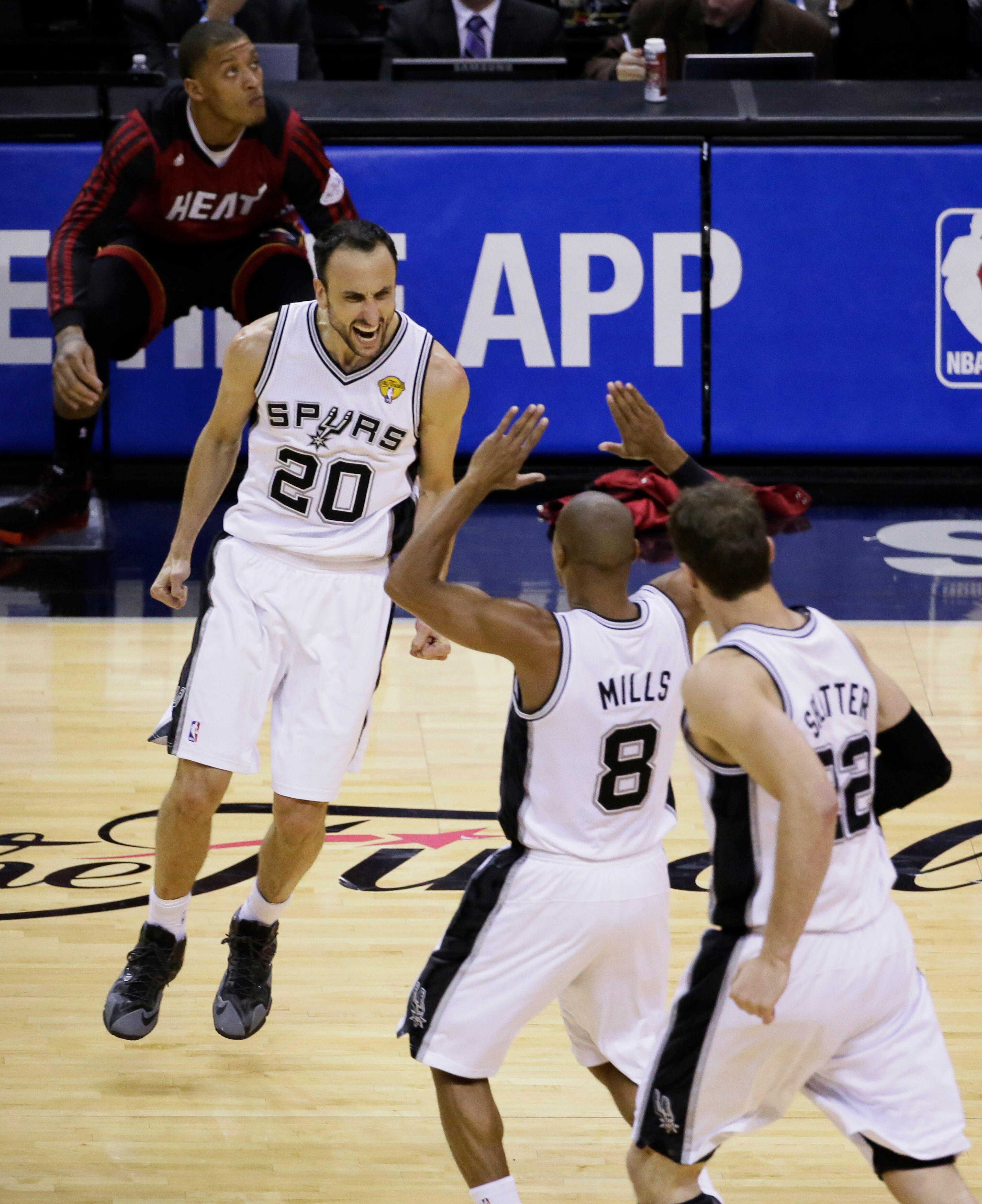 San Antonio Spurs guard Manu Ginobili (20), guard Patty Mills (8) and center Tiago Splitter (22) celebrate against the Miami Heat during the second half in Game 5 of the NBA basketball finals on Sunday, June 15, 2014, in San Antonio. (AP Photo/Tony Gutierrez)