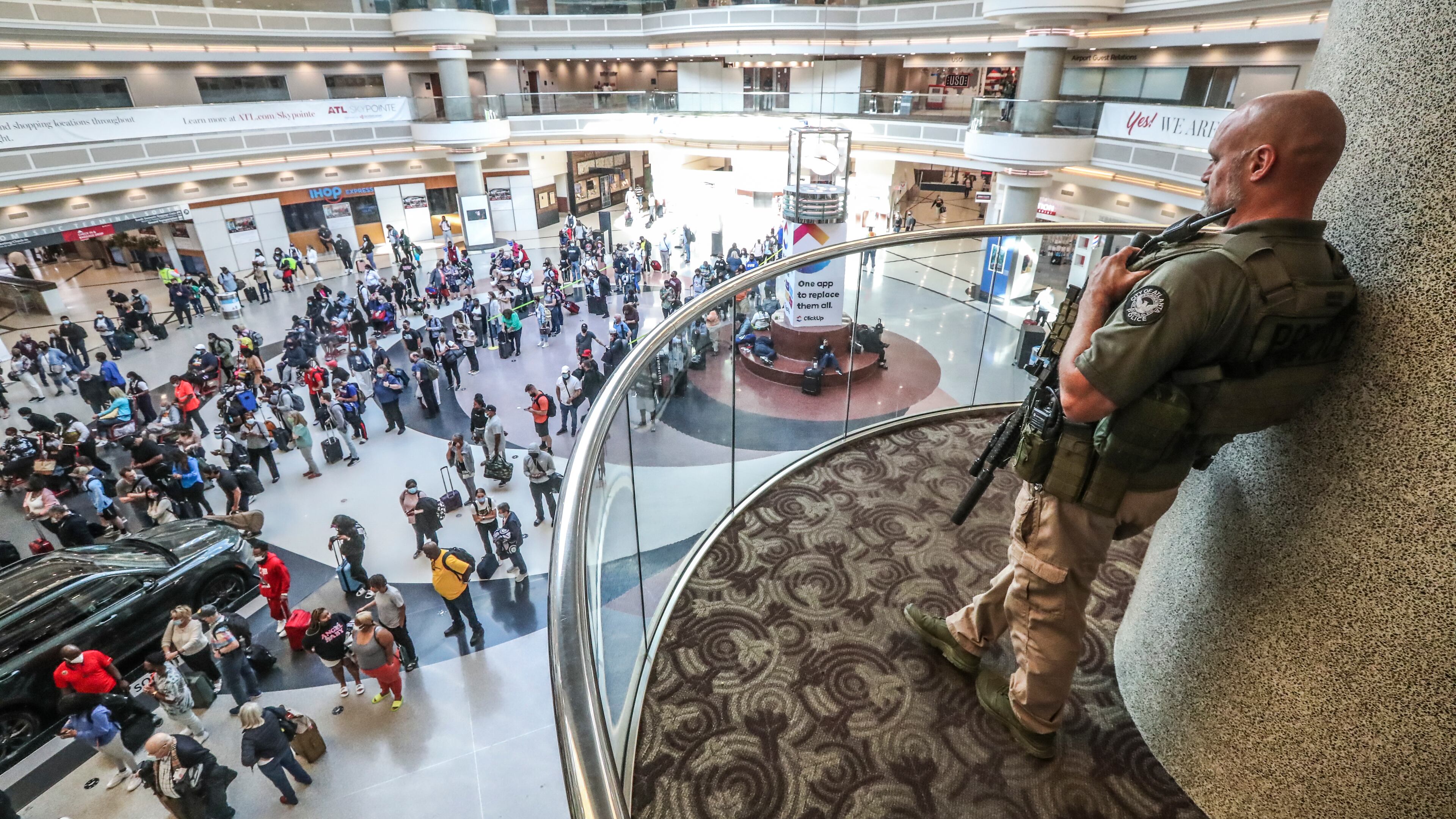 Atlanta police officer, J. Overbaugh overlooks lines of travelers in the atrium at Hartsfield-Jackson Atlanta International Airport early Monday morning, May 17, 2021.
