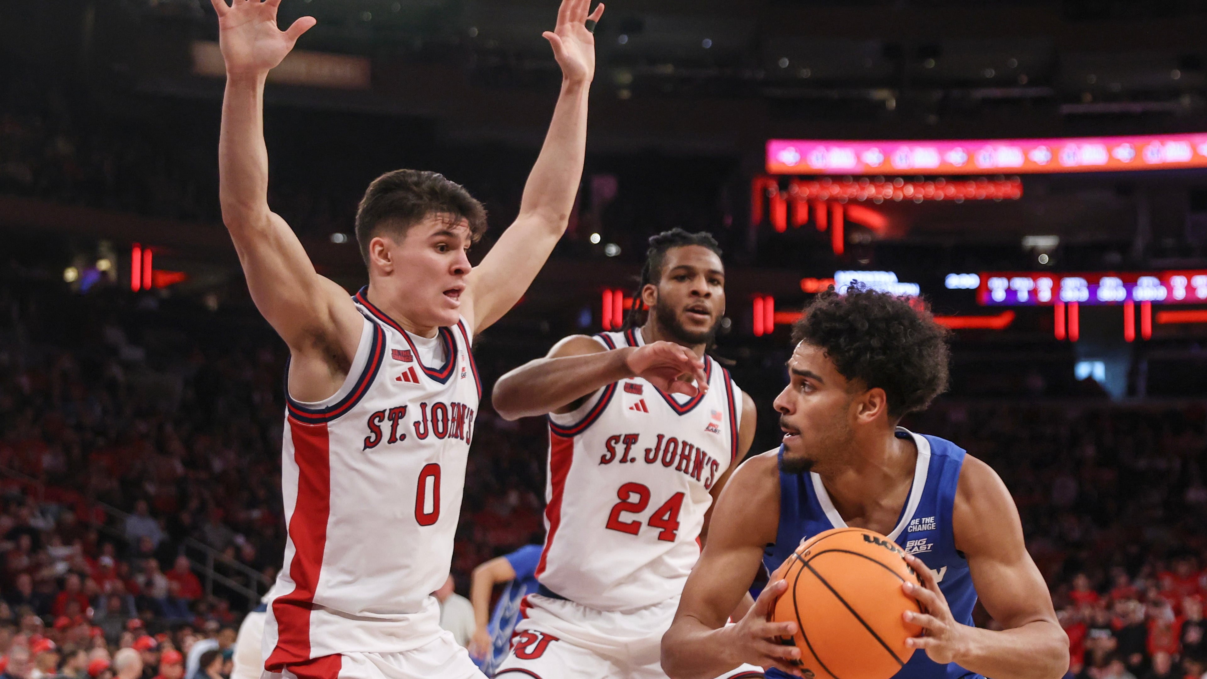 Creighton guard Nik Graves is defended by St. John's guard Dylan Darling (0) and forward Zuby Ejiofor (24) during the first half of an NCAA college basketball game, Saturday, Feb. 21, 2026, in New York. (AP Photo/Heather Khalifa)