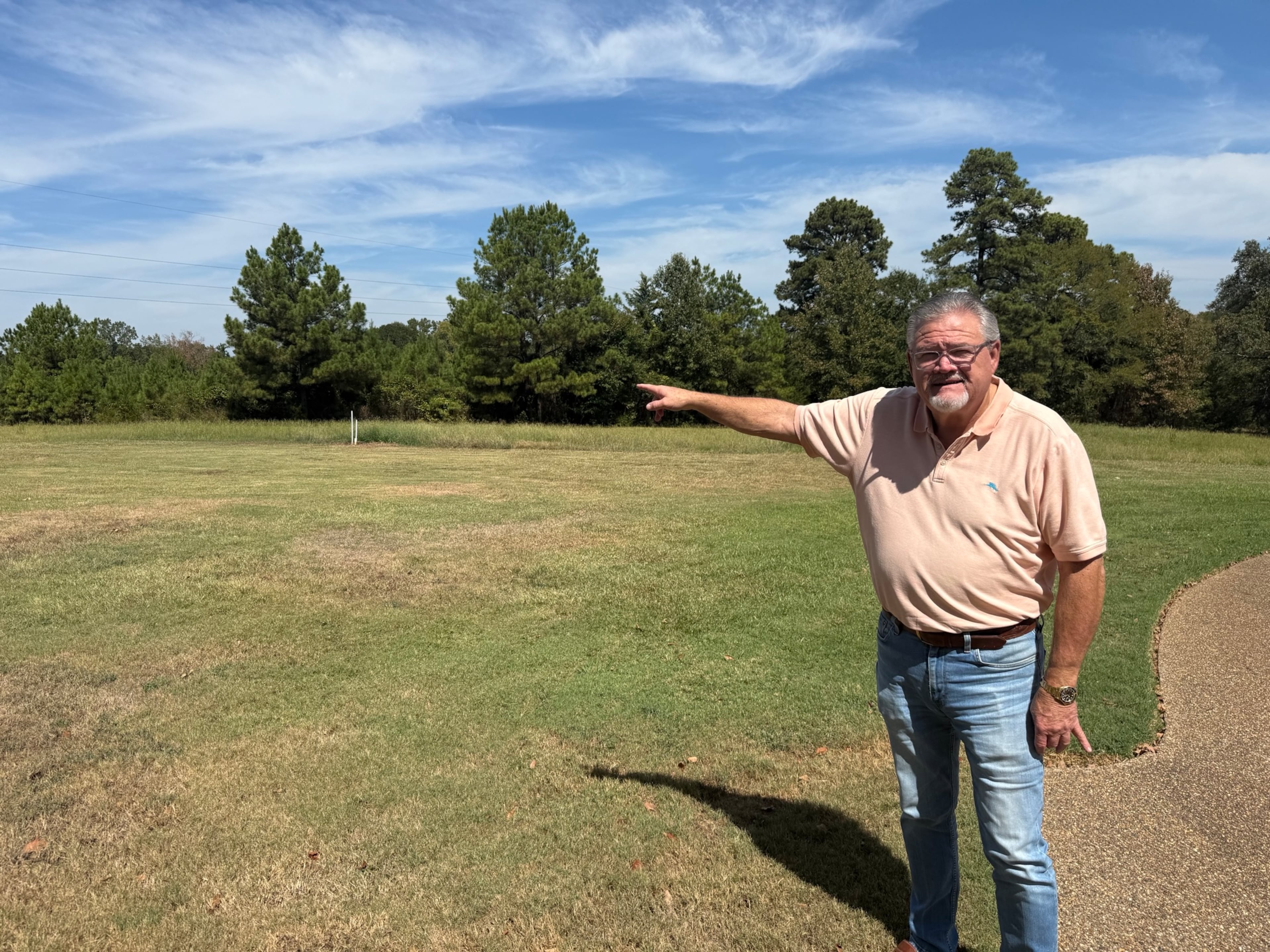 Danny Proctor points to a proposed data center project just beyond the tree line of his property near Texarkana, Texas. The retired insurance executive has led the community's fight against data center projects, including one from Republican GOP nominee Rick Jackson. (Greg Bluestein/AJC).