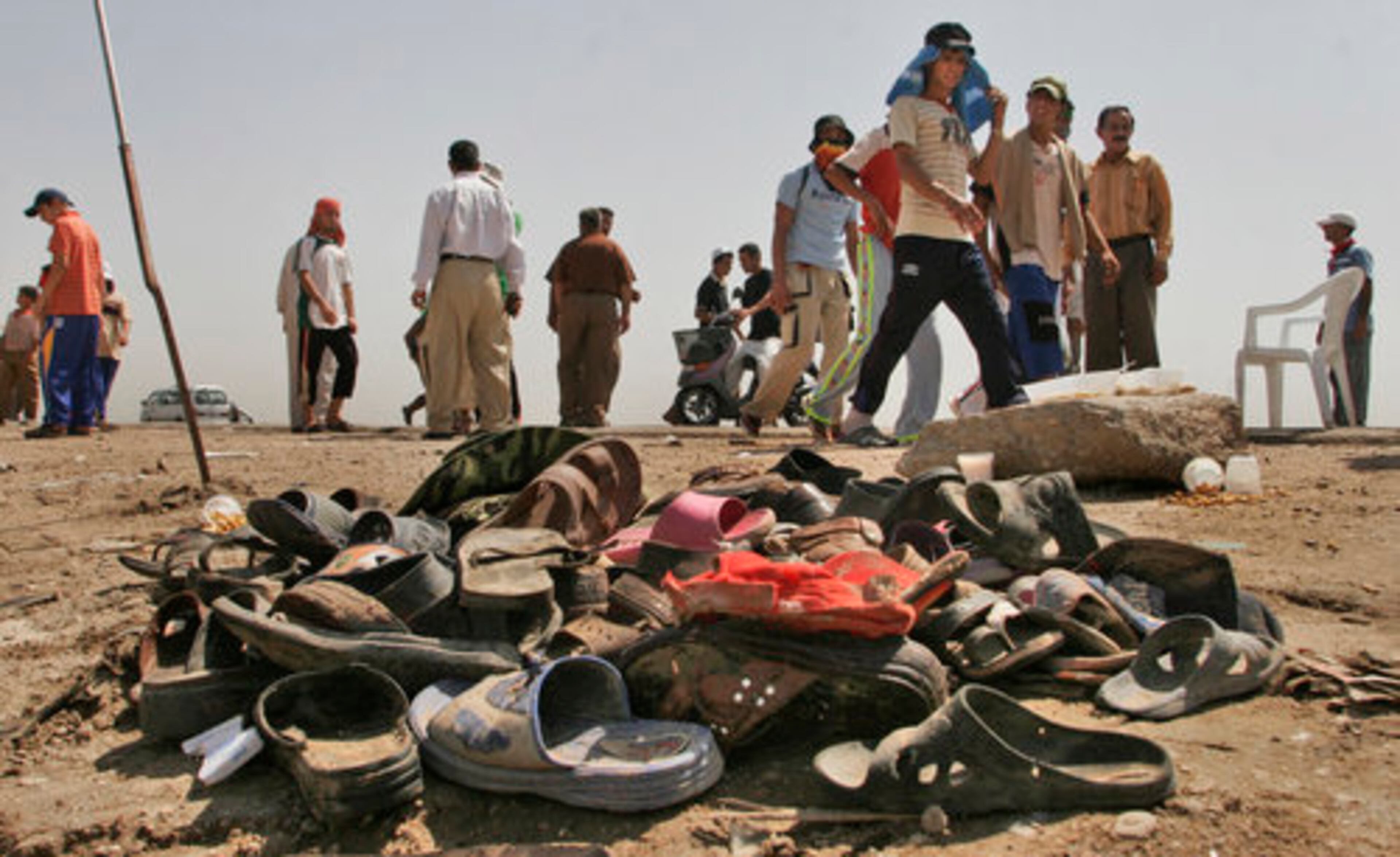 In Iskandariyah, Iraq, on Friday, Shiite pilgrims walk past a pile of shoes belonging to the victims of Thursday's suicide bombing that killed at least 18 people and wounded 75 attending the Shabaniyah festival.