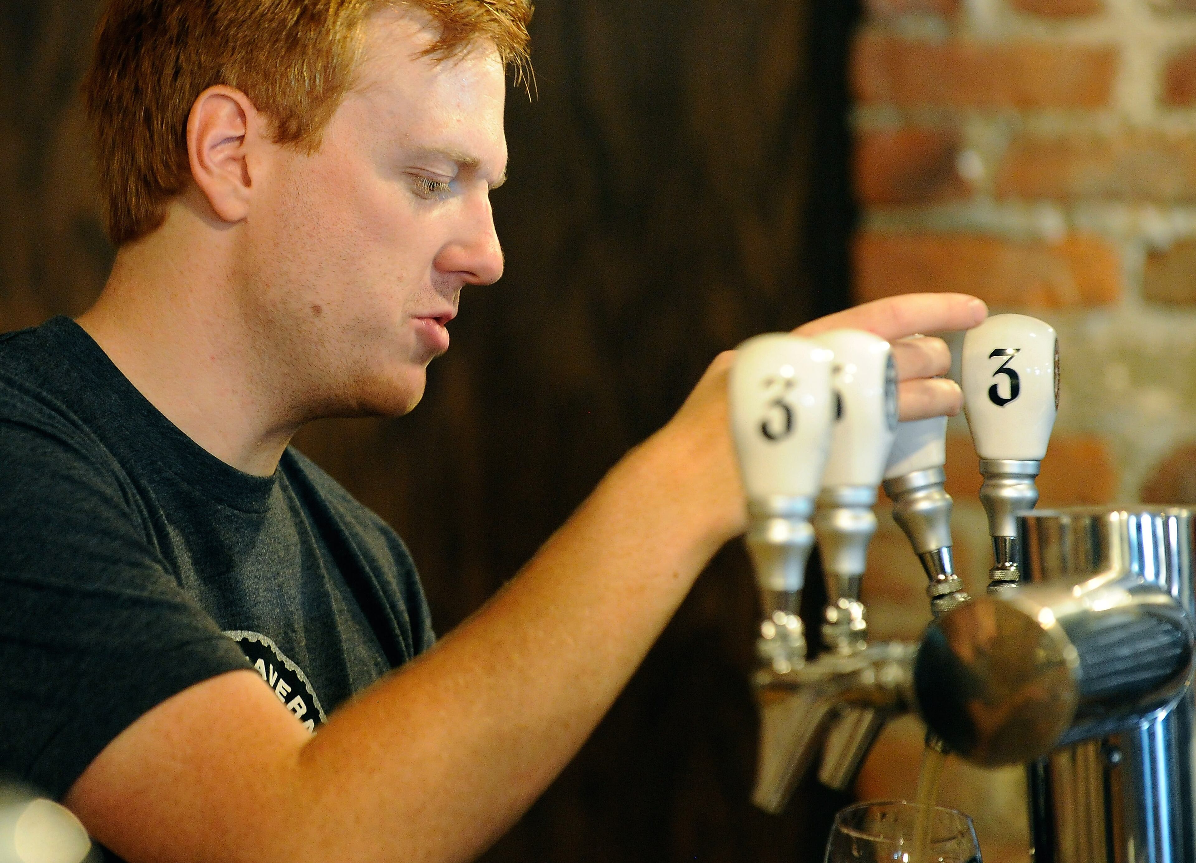 Three Taverns Craft Brewery's Danny Ritchie pours from a tap as he helps celebrate the establishment's one-Year Anniversary with hundreds of beer aficionados on Saturday, July 19, 2014, in Decatur, Ga. David Tulis / AJC Special