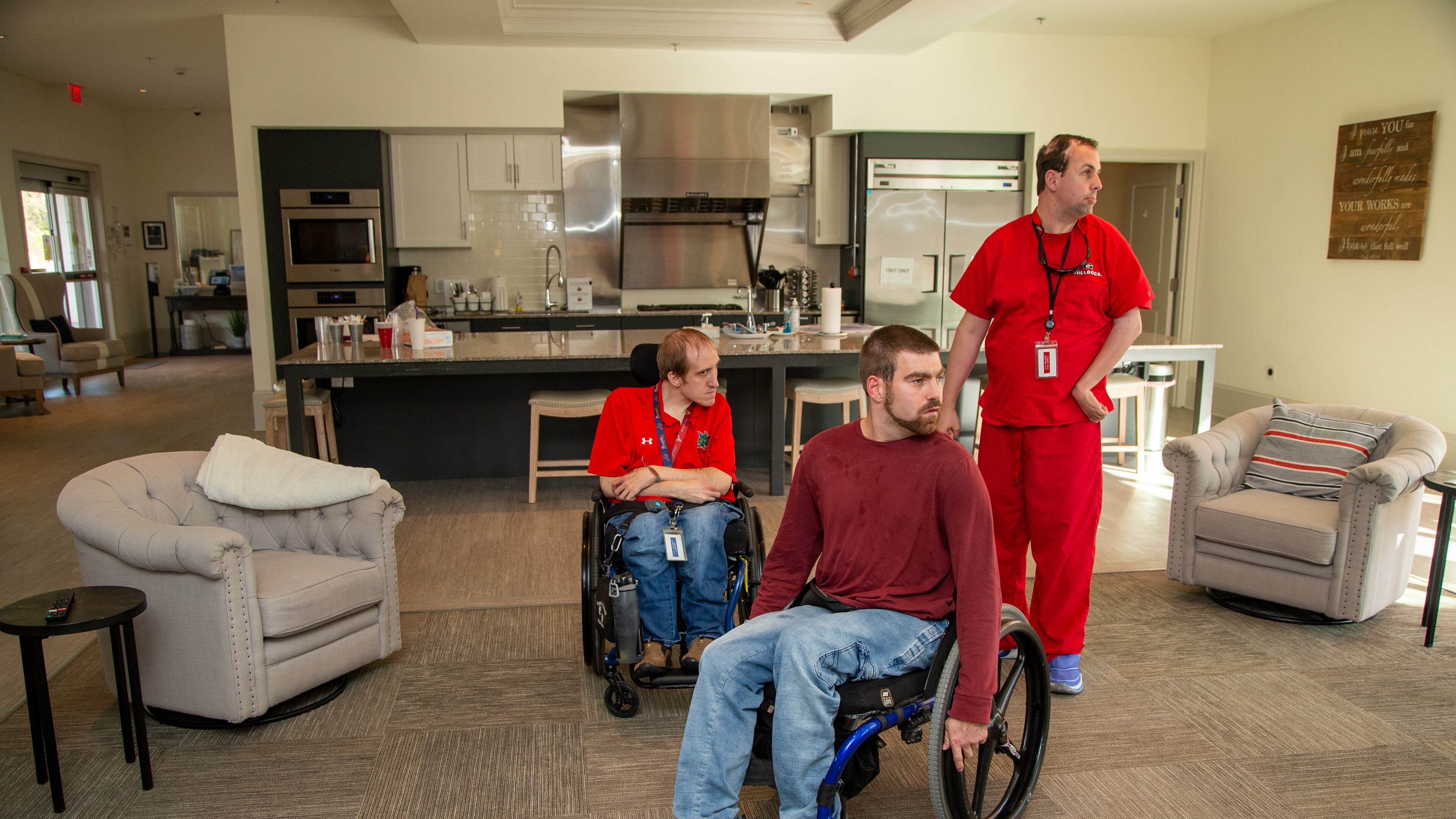 Residents Adam Laarhoven (from left), Matt Thompson and Ryan Carroll get settled in the main room at Champions Place. The facility is a first-of-a-kind residential community for physically challenged young adults. PHIL SKINNER FOR THE ATLANTA JOURNAL-CONSTITUTION.