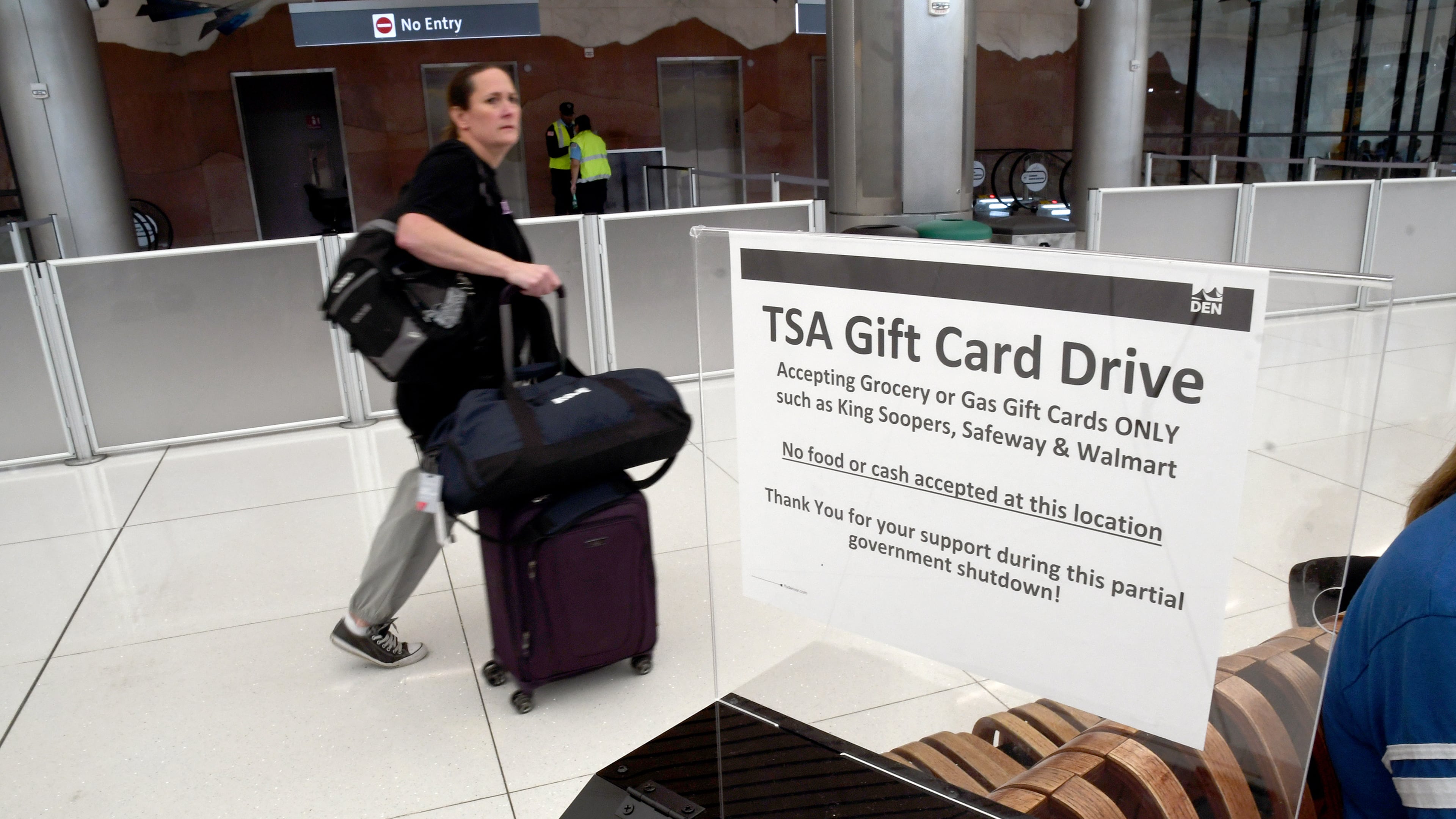 A traveler walks past a gift card donation box for Transportation Security Administration officers at Denver International Airport on Friday, March 20, 2026. (AP Photo/Thomas Peipert)