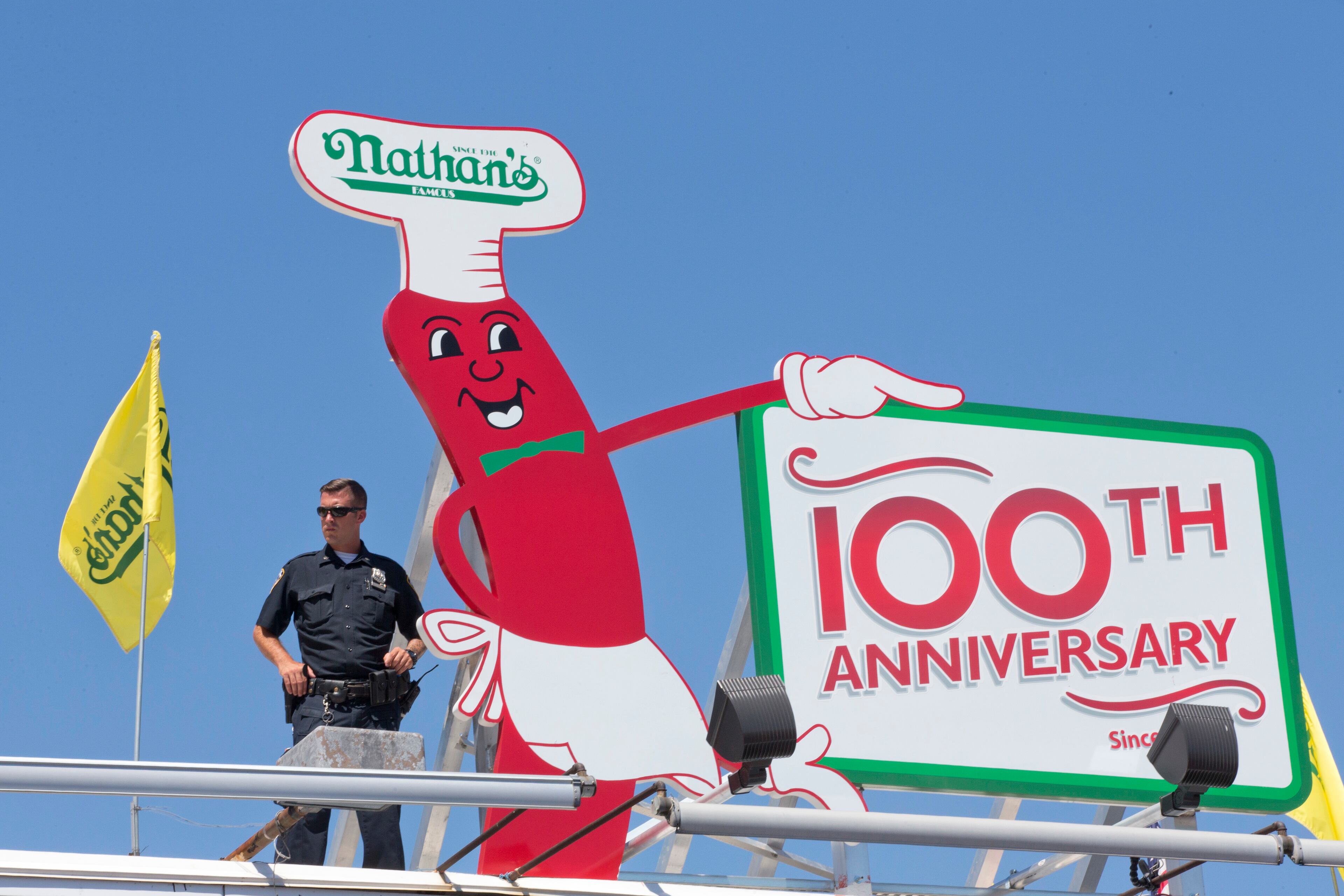 A police officer stands guard on the roof of Nathan's Famous store during the Fourth of July International Hot Dog Eating Contest, Monday, July 4, 2016, in New York. (AP Photo/Mary Altaffer)