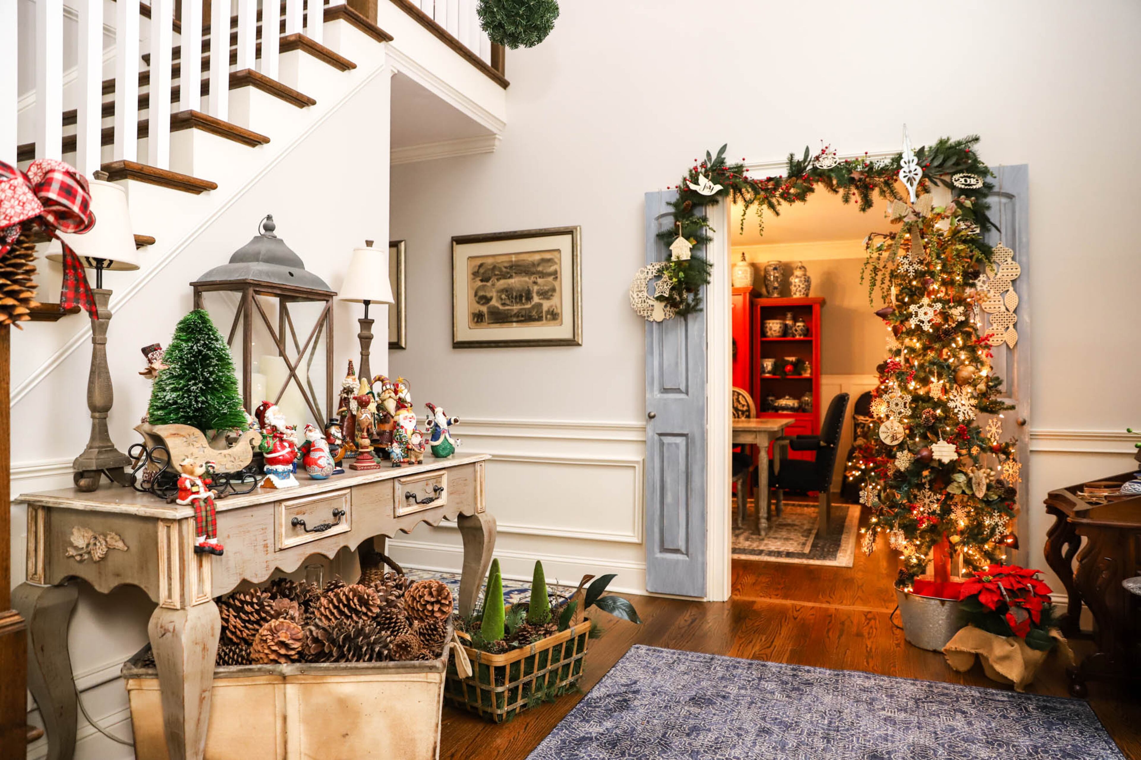 The foyer of Steve Stephens and Jennifer Stambek’s home bursts with festive decor for the holidays. One of Stambek’s trees stands by the door to the dining room, covered in laser cut snowflakes, and a captain’s desk that Stambek found at an antique store serves as a console table, housing her Santa Claus collection. Text by Shannon Dominy. Photo by Reynolds Rogers.