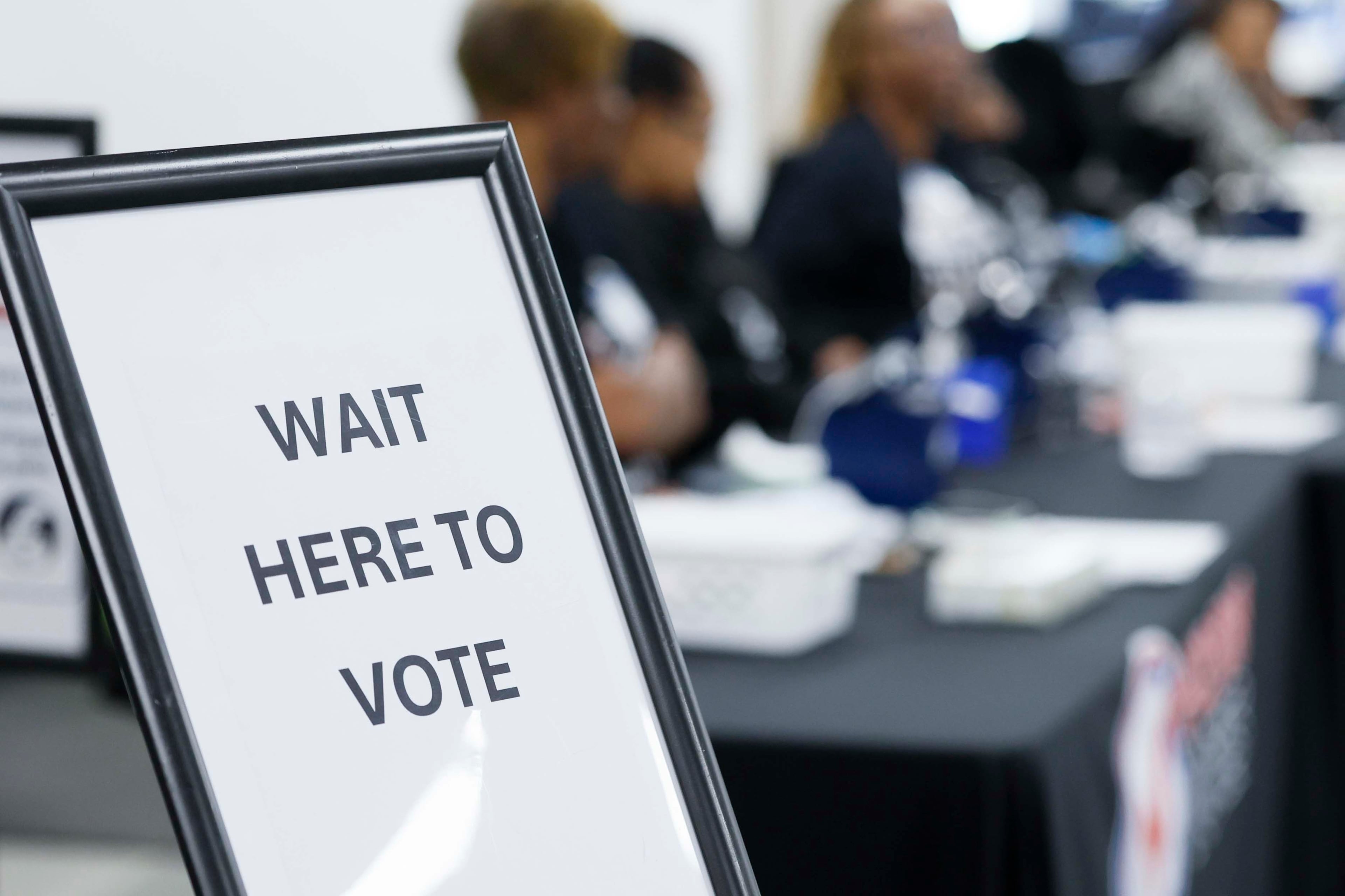 A sign directs people to where to wait to start the voting process inside the Fulton County Registration and Elections office during early voting on Monday. (Miguel Martinez/AJC)