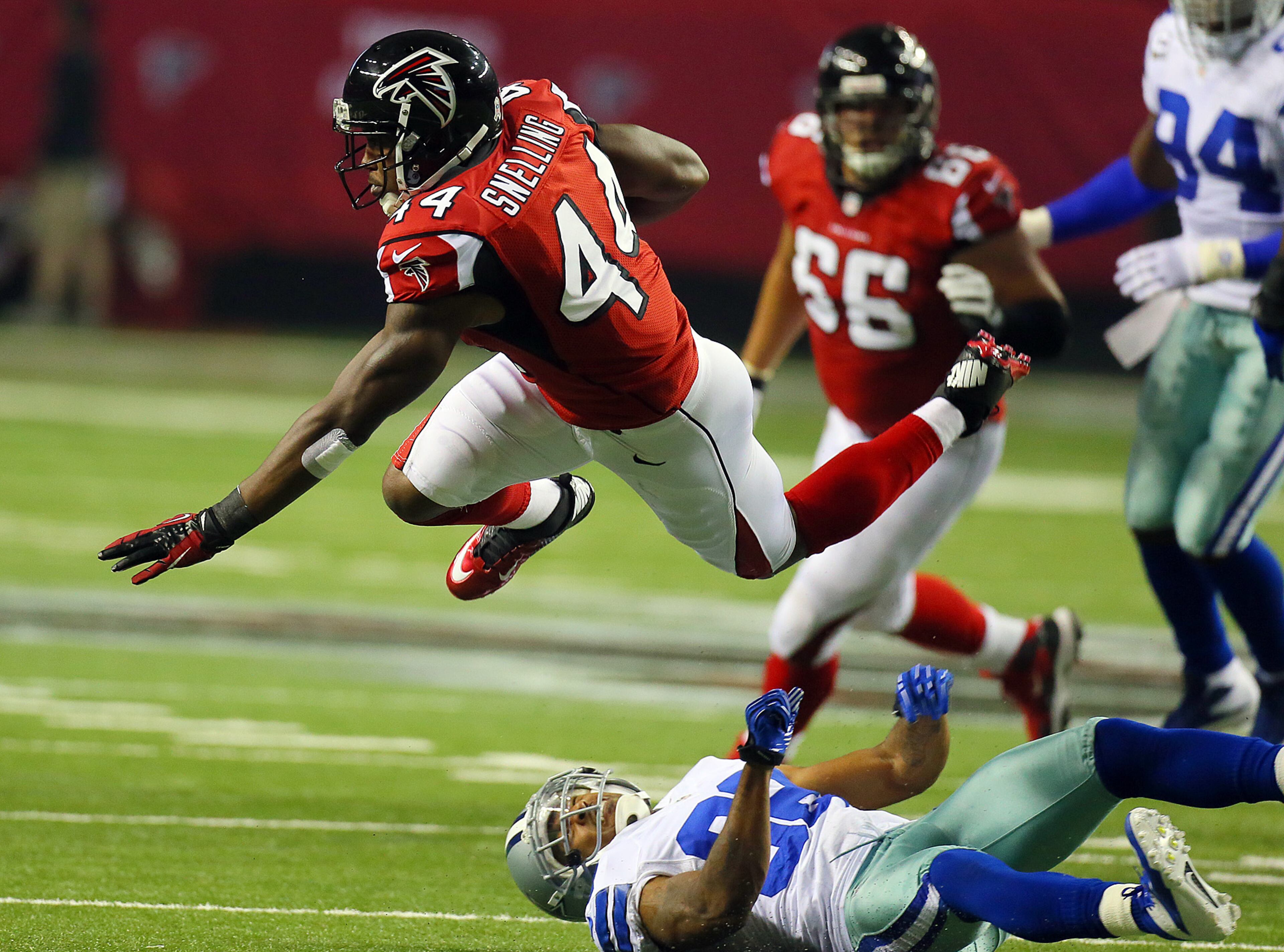 Falcons running back Jason Snelling picks up a couple of yards setting up a Falcons field goal as he is sent airborne on a hit by Dallas Cowboys cornerback Orlando Scandrick during 1st half action at the Georgia Dome in Atlanta on Sunday, Nov. 4, 2012. CURTIS COMPTON / CCOMPTON@AJC.COM