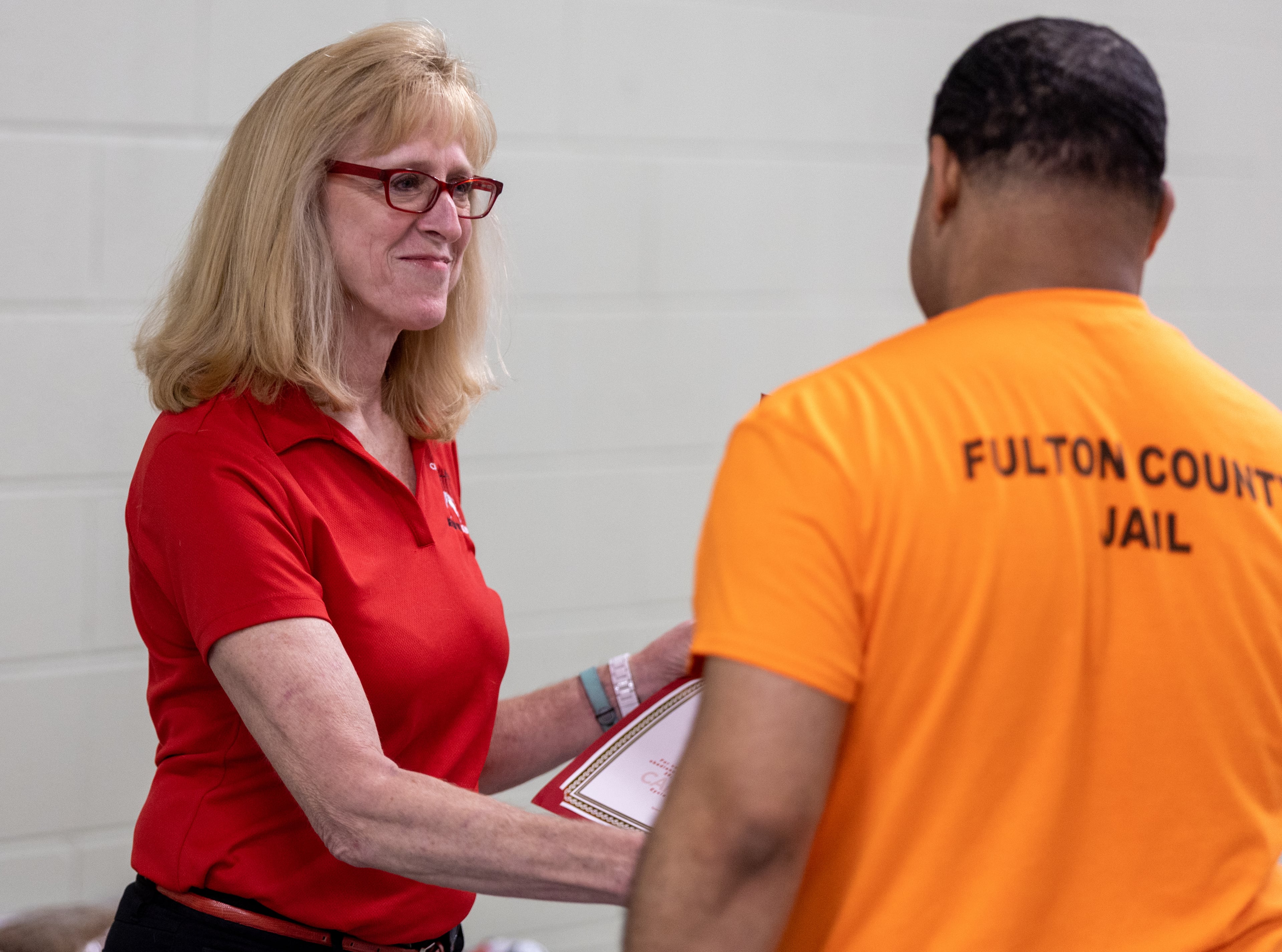 Susan Jacobs-Meadows hands a diploma to Inmate/handler Brandon McGill during the graduation ceremony Friday, Sep. 09, 2022. (Steve Schaefer/steve.schaefer@ajc.com)
