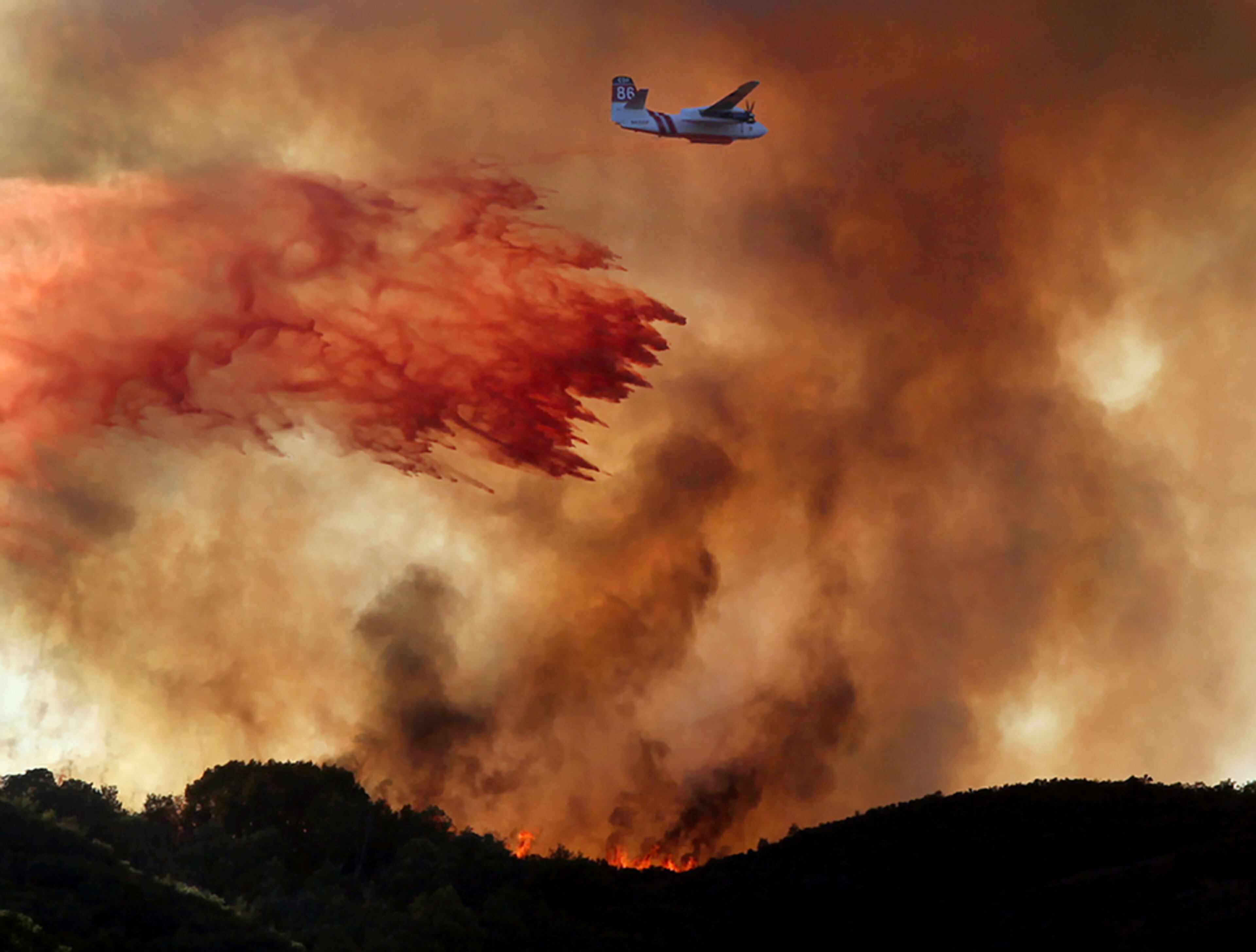 FIGHTING FIRE--A Cal Fire air tanker drops a load of fire retardant across the head of the Scotts Fire above Scotts Valley in Lake County, Calif., Friday Sept. 7, 2012.