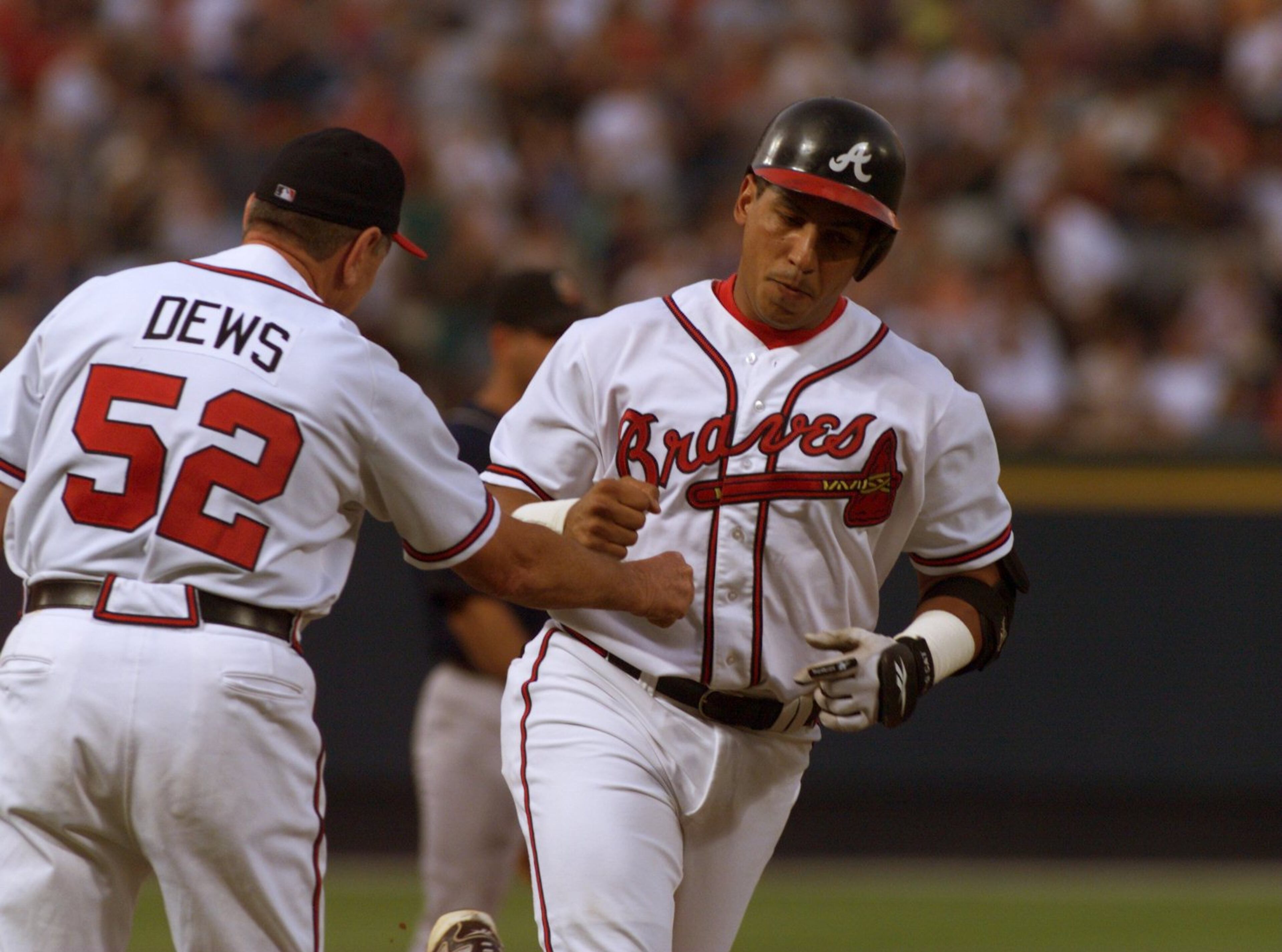980821 - Atlanta, Georgia - Braves' first baseman Andres Galarraga (R) gets a fist full of congratulations from third base coach Bobby Dews (L) after his two-run homer in 1st inning action at Turner Field Friday, August 21, 1998. (AJC Staff Photo/David Tulis)