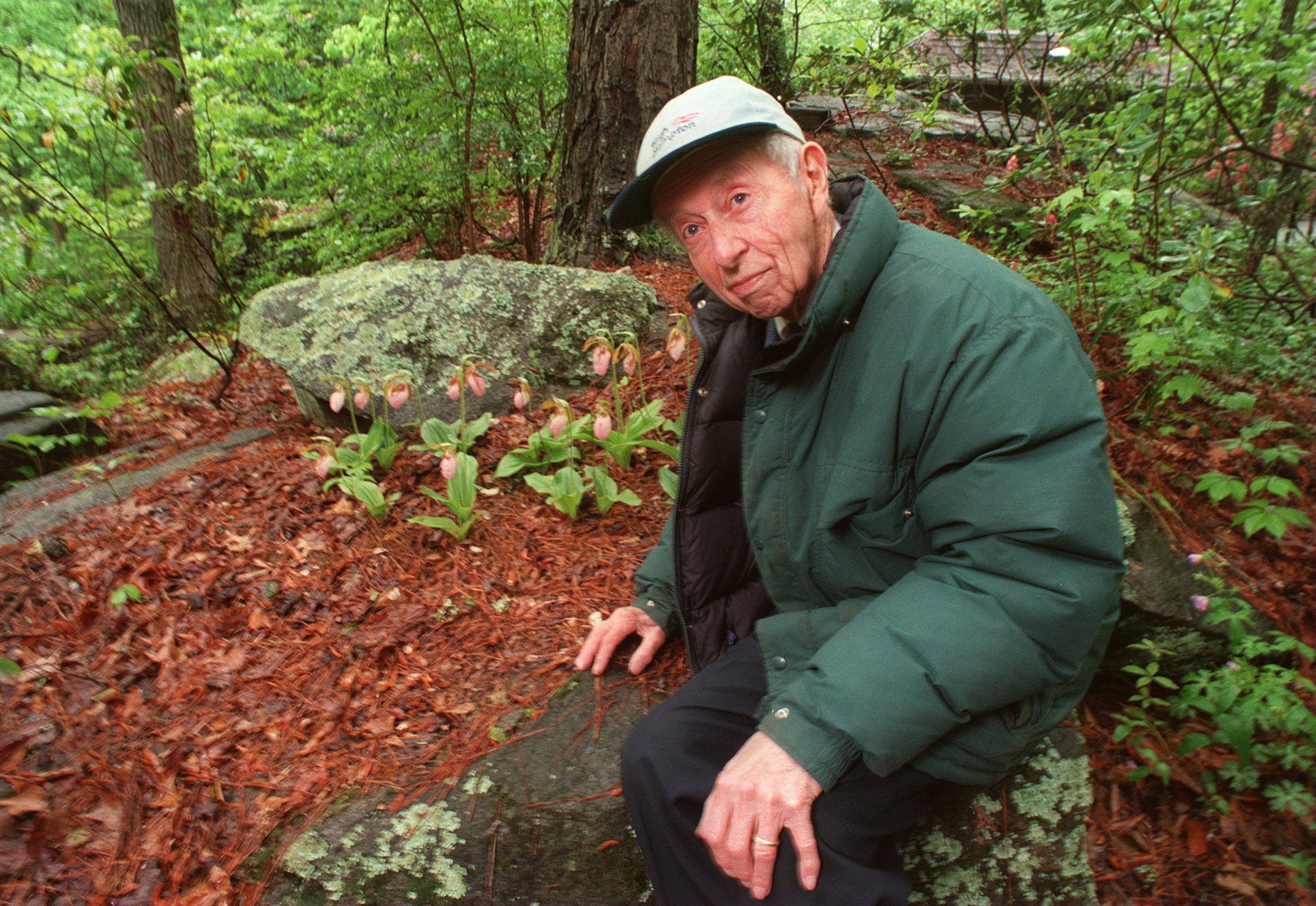 Atlanta naturalist John Ripley Forbes helped create the Chattahoochee Nature Center in 1976. Behind him are some native wild orchids that he saved from development at his Dunwoody home in 1998. (Louie Favorite/AJC)