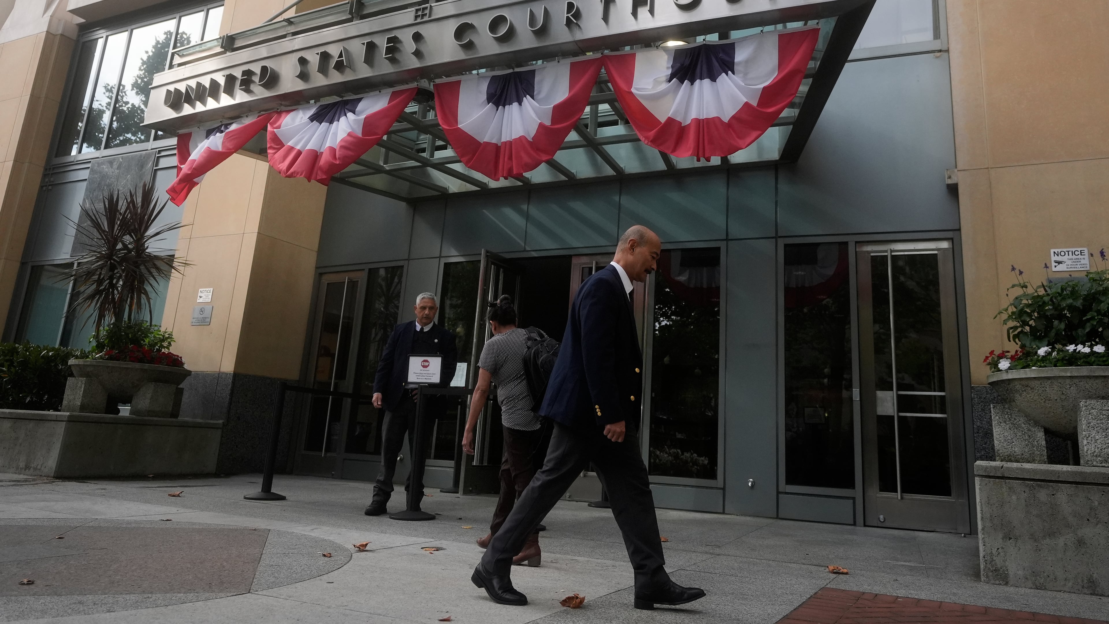 People walk outside of a Federal Courthouse Wednesday, Aug. 12, 2026, in Oakland, Calif. (AP Photo/Jeff Chiu)