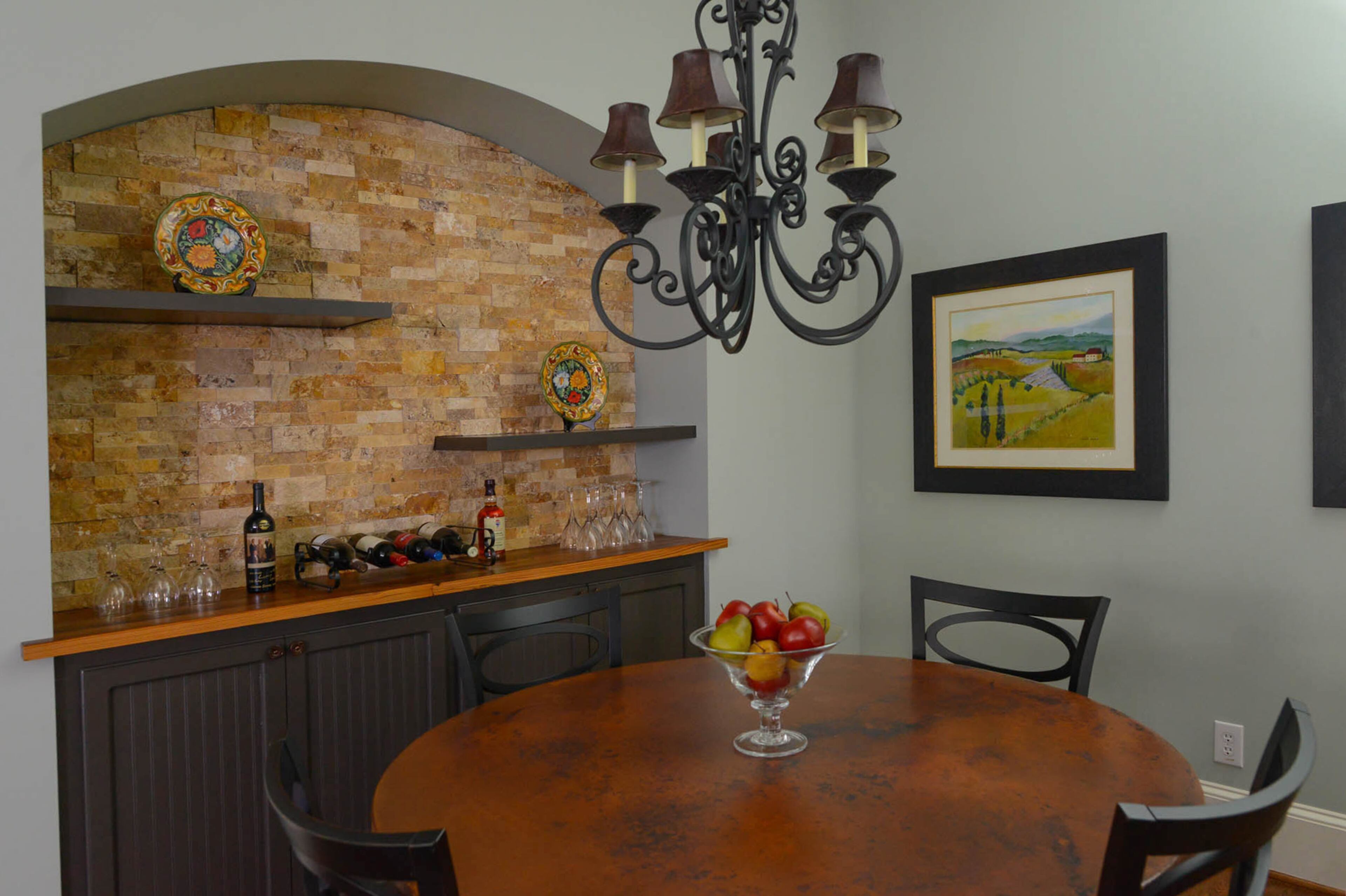 The breakfast nook is filled with statement transitional pieces like the round breakfast table with a copper top from Arhaus and the reclaimed wood and stone tile accent wall behind the buffet nook. The new look for the nook is among about $41,000 in renovations to the Alpharetta home.
