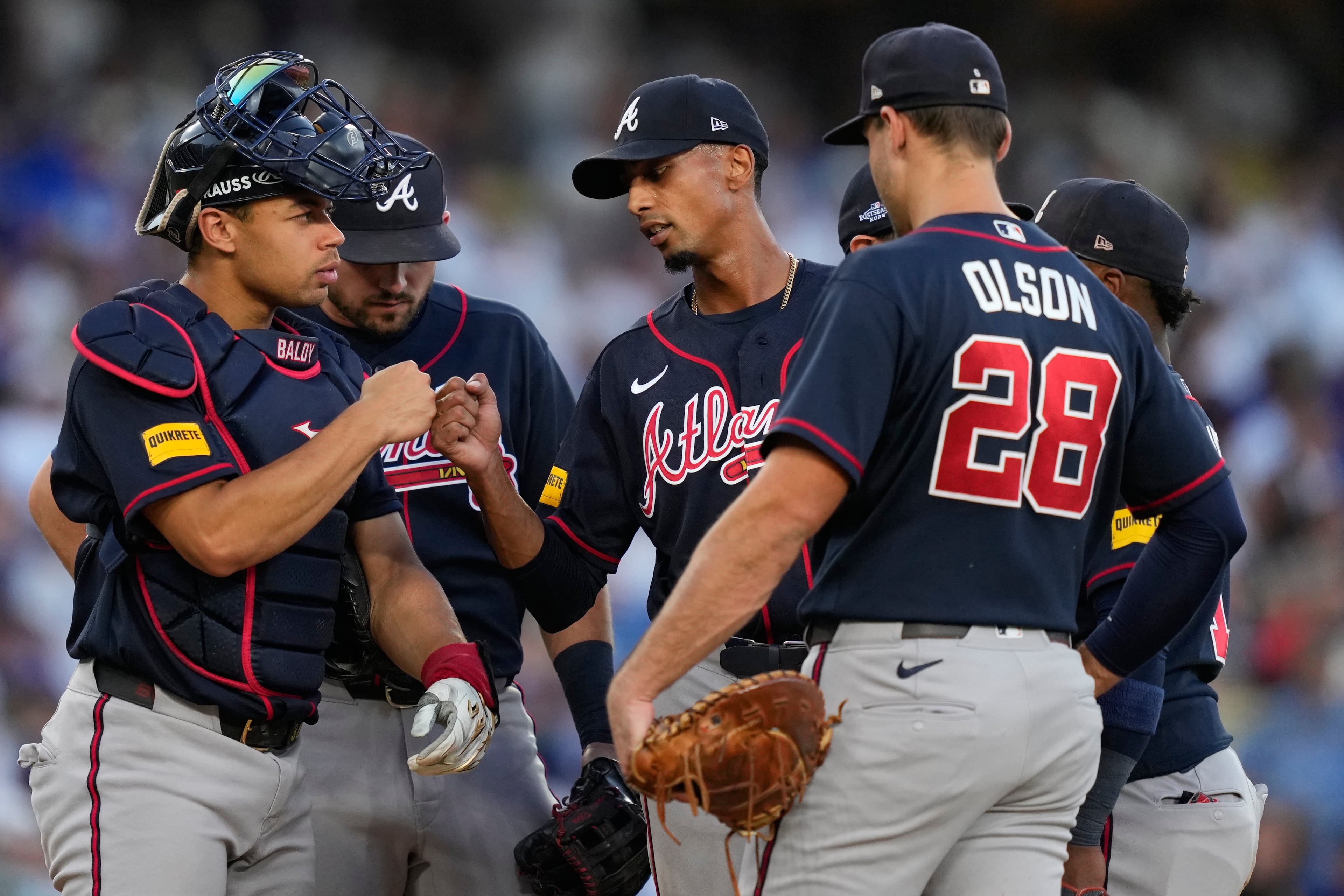 Atlanta Braves starting pitcher Ray Kerr, center, bumps fists with catcher Drake Baldwin as he exits during the third inning of Game 2 of a National League Division Series baseball game against the Los Angeles Dodgers Sunday, Oct. 4, 2026, in Los Angeles. (AP Photo/Mark J. Terrill)