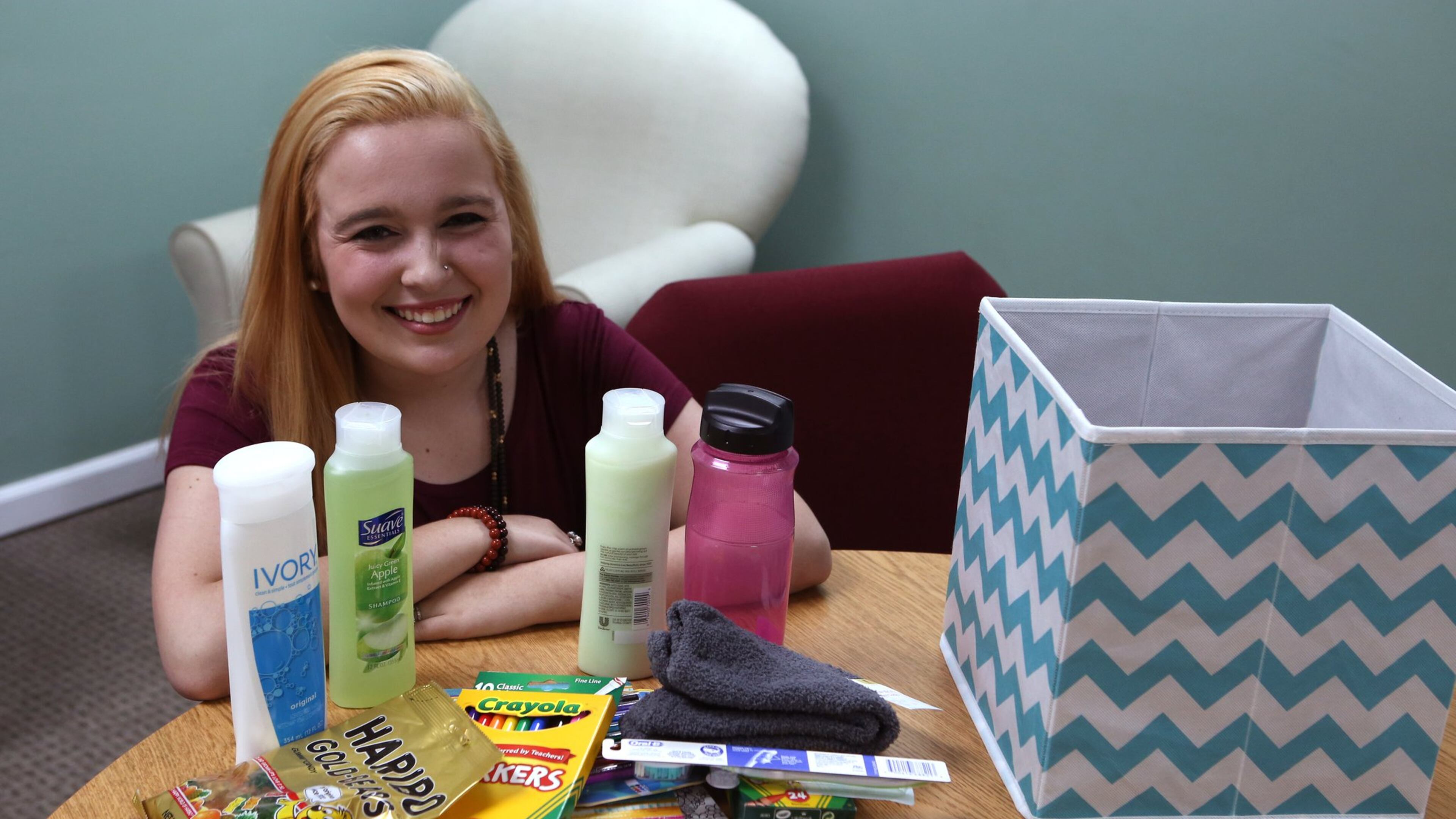 Kristina Welch, 19, with an assortment of items from a care package that is part of a service project she started called The Julia Project. She puts together the packages for teenagers living in halfway homes as they to recover from addiction. She began the project after losing her own cousin, Julia Sanchez, to a drug overdose. (HENRY TAYLOR / HENRY.TAYLOR@AJC.COM)