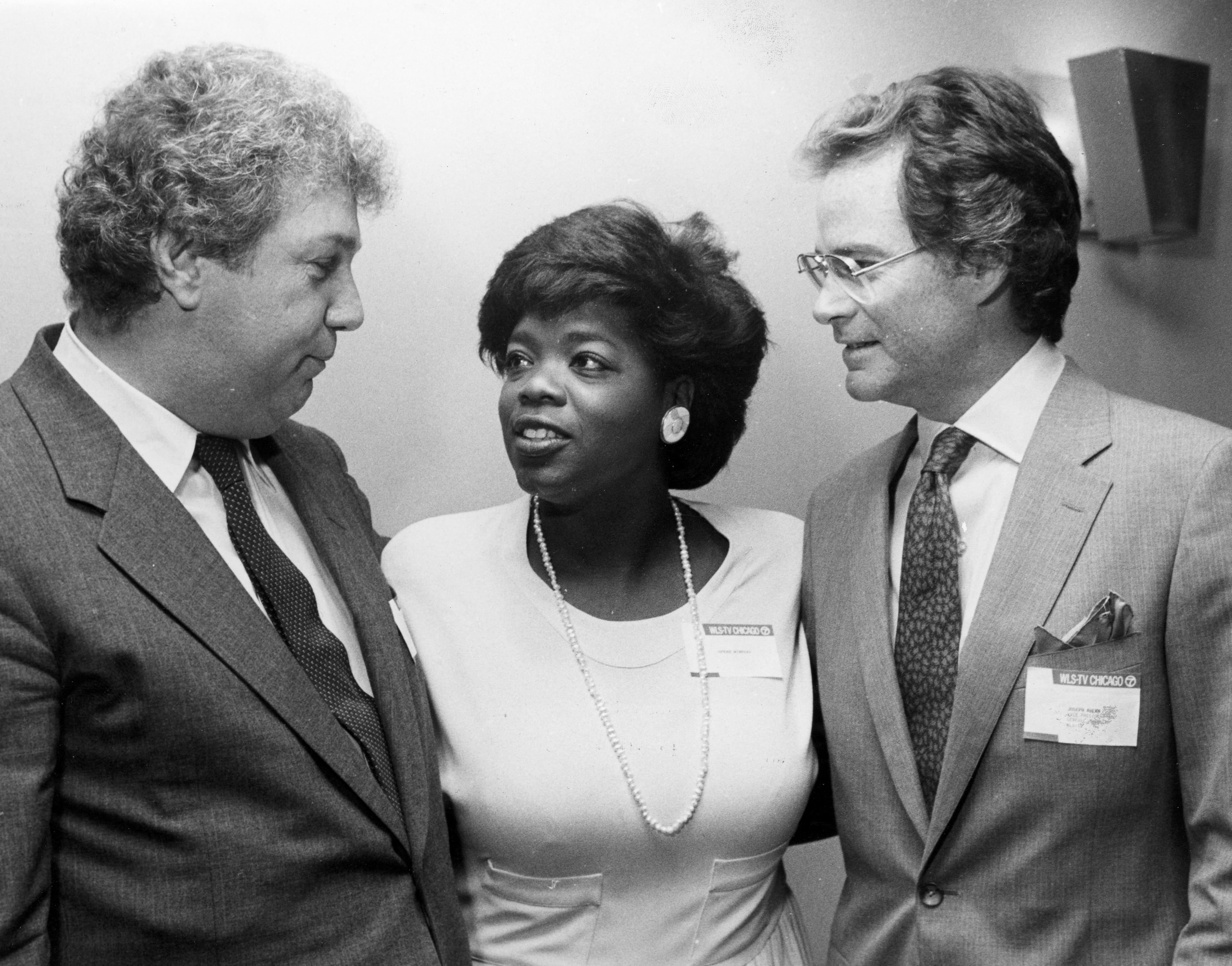 Oprah Winfrey joins Roger King, left, chairman of the board of King World, and Joseph Ahern, right, former general manager of WLS-TV, at a news conference in Chicago in July 24, 1985 where it was announced that "The Oprah Winfrey Show" will be syndicated nation-wide beginning Sept. of 1986. (AP Photo/Charlie Bennet)