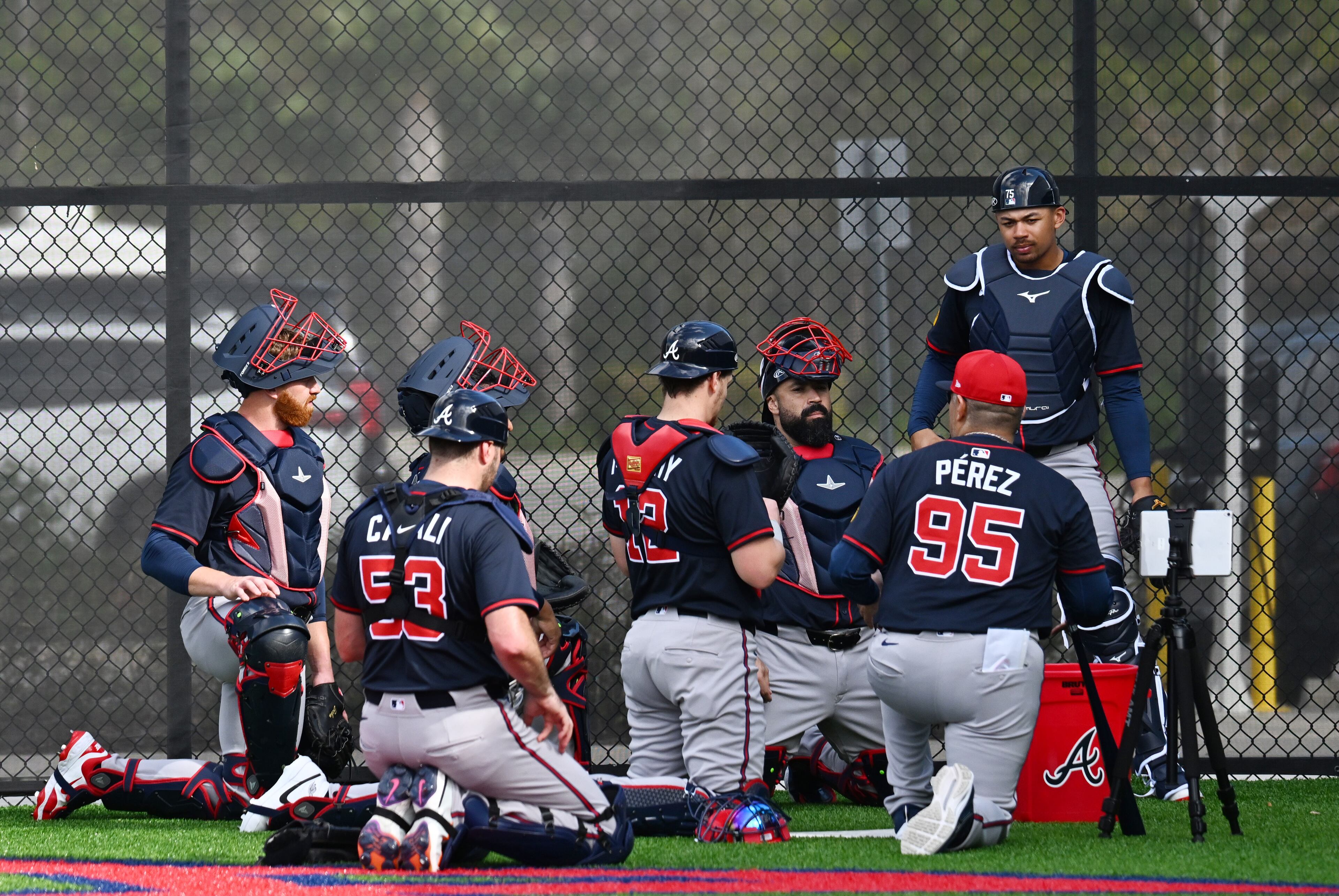 Atlanta Braves coach Eddie Pérez (95) confers with catchers during spring training workouts at CoolToday Park, Thursday, February 13, 2025, North Port, Florida. (Hyosub Shin / AJC)