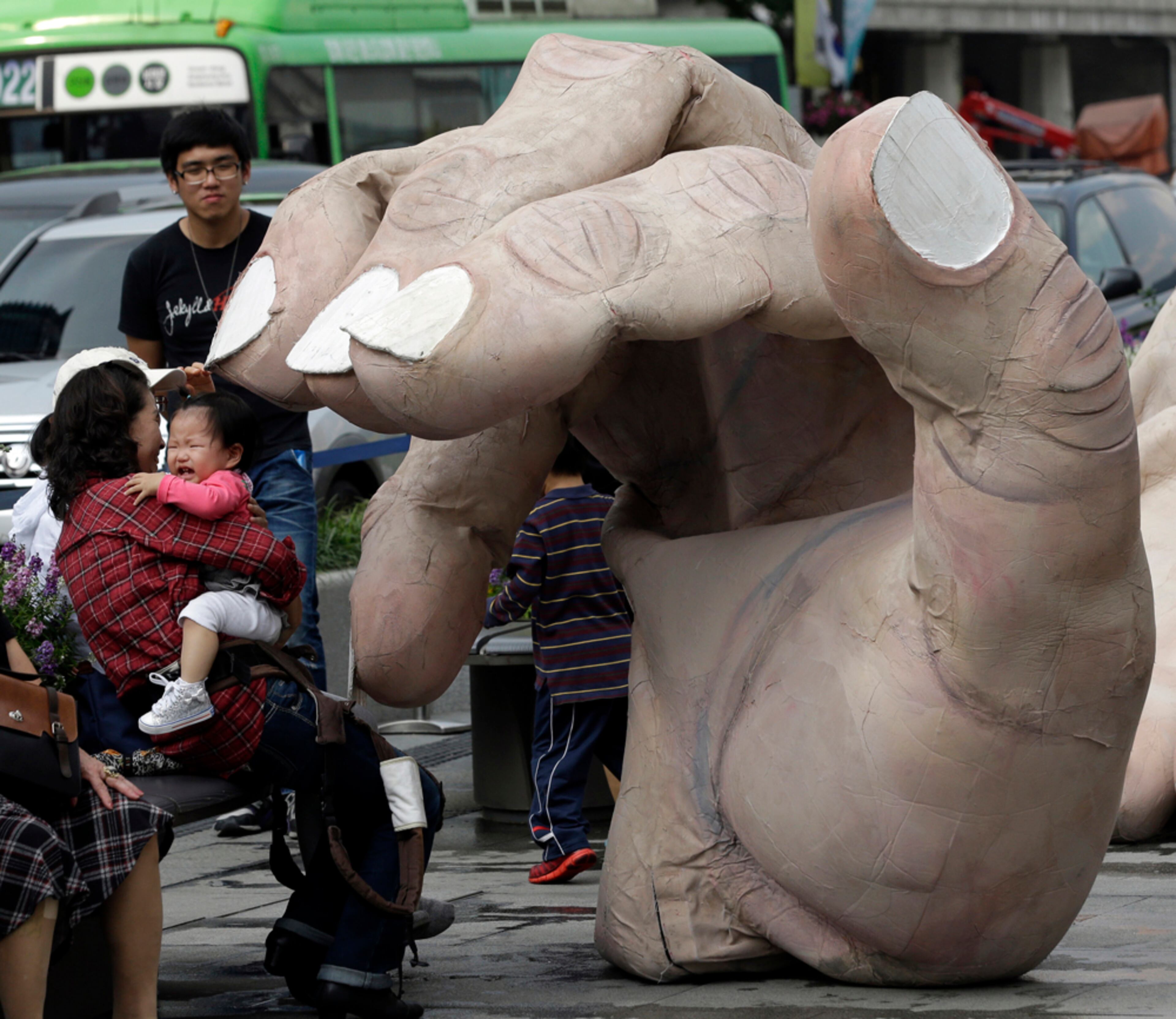 NO TALKING TO THIS HAND--A girl cries as a massive hand approach to her during the Human Body Parts performance on a street in Seoul, South Korea, Thursday, Oct. 4, 2012. The performance is part of the Hi Seoul Festival which runs from Oct. 1 through Oct. 7.