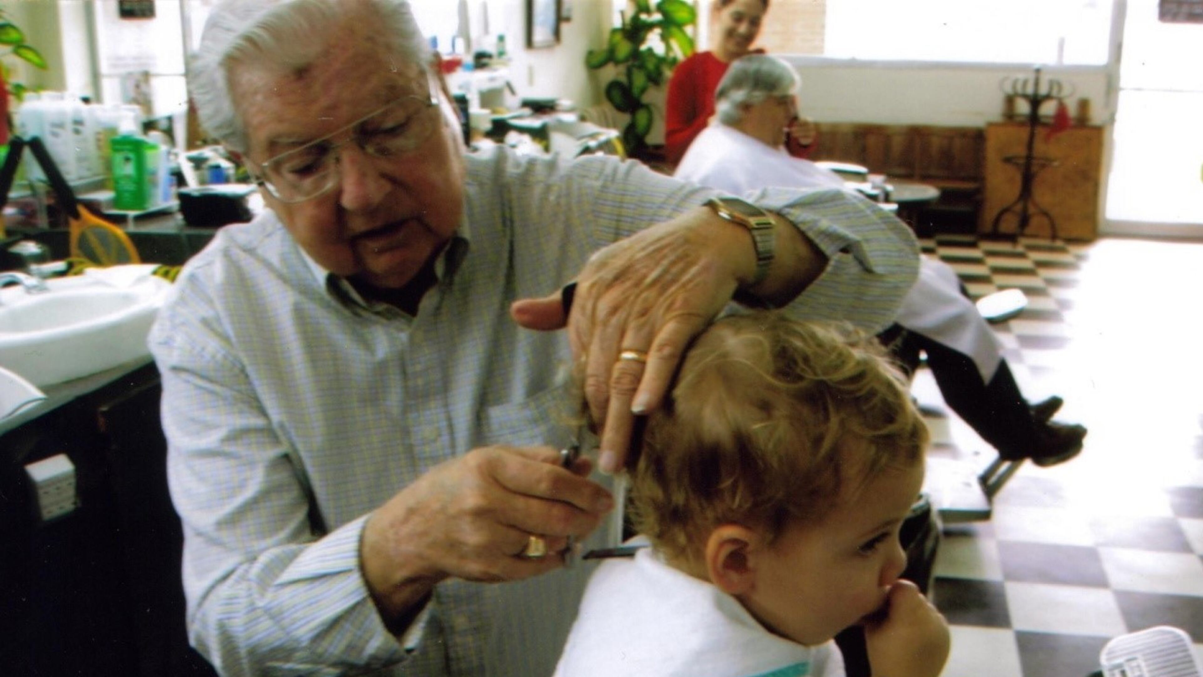 Burges gives 2-year-old Benjamin Maxwell of Dunwoody his first haircut. Burges also gave Benjamin’s father, Tucker native Brad Maxwell, his first haircut as well.
