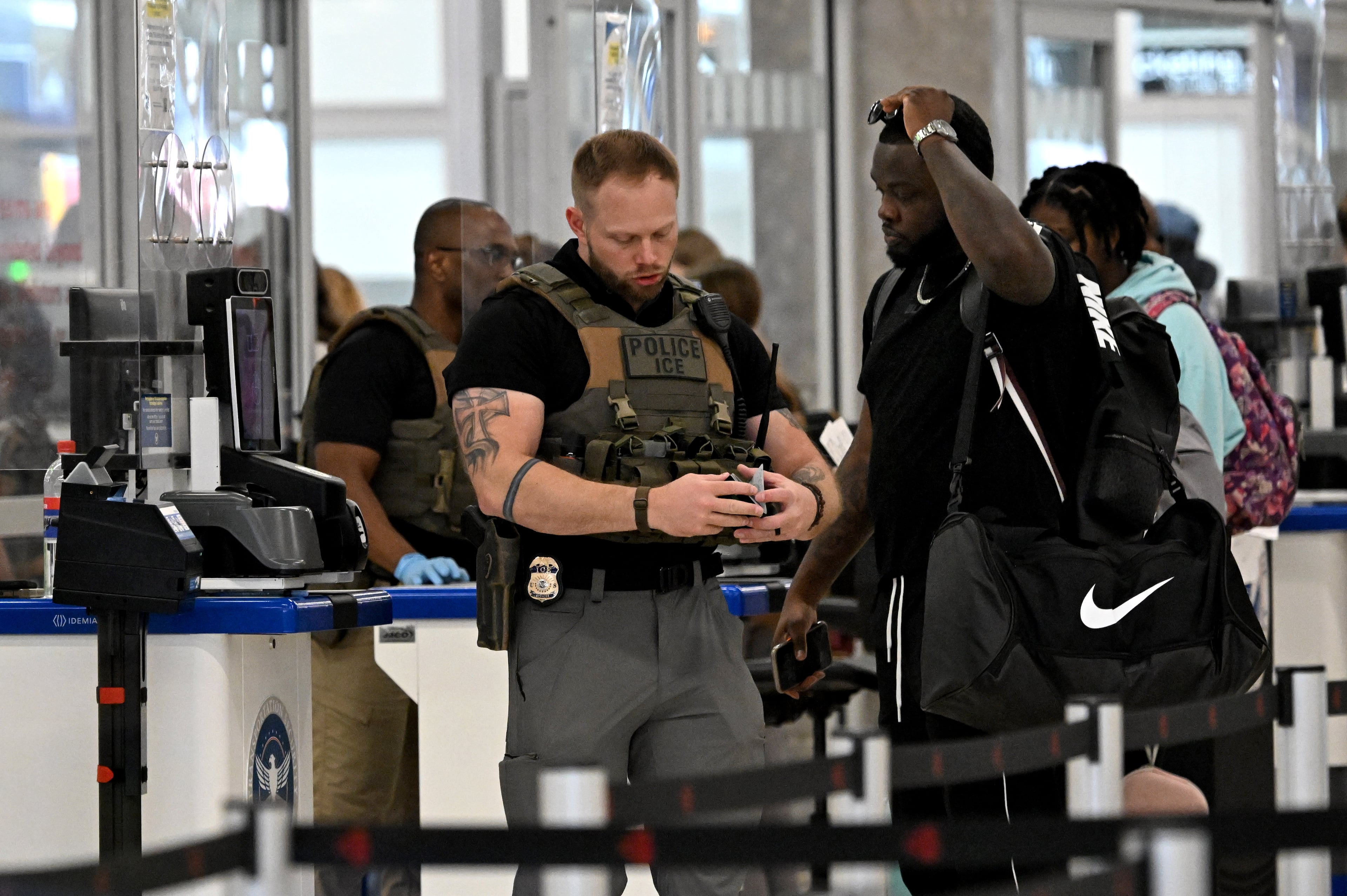 Immigration and Customs Enforcement agents work a TSA checkpoint at Hartsfield-Jackson Atlanta International Airport on Friday, March 27, 2026. Hartsfield-Jackson has been part of a reported increase in ICE agents at airports across the country. (Hyosub Shin/AJC)