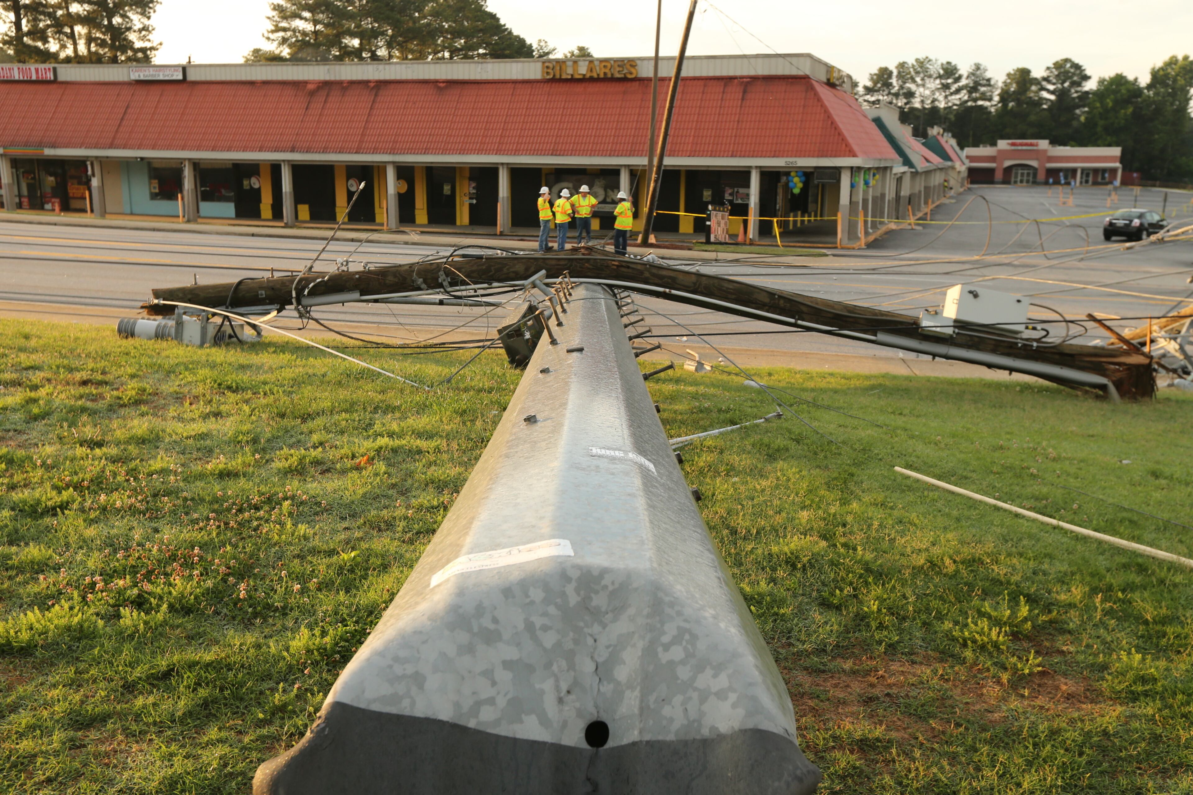 A second pole also fell onto a nearby grassy area. It was not immediately clear what caused the poles to topple. JOHN SPINK/JSPINK@AJC.COM