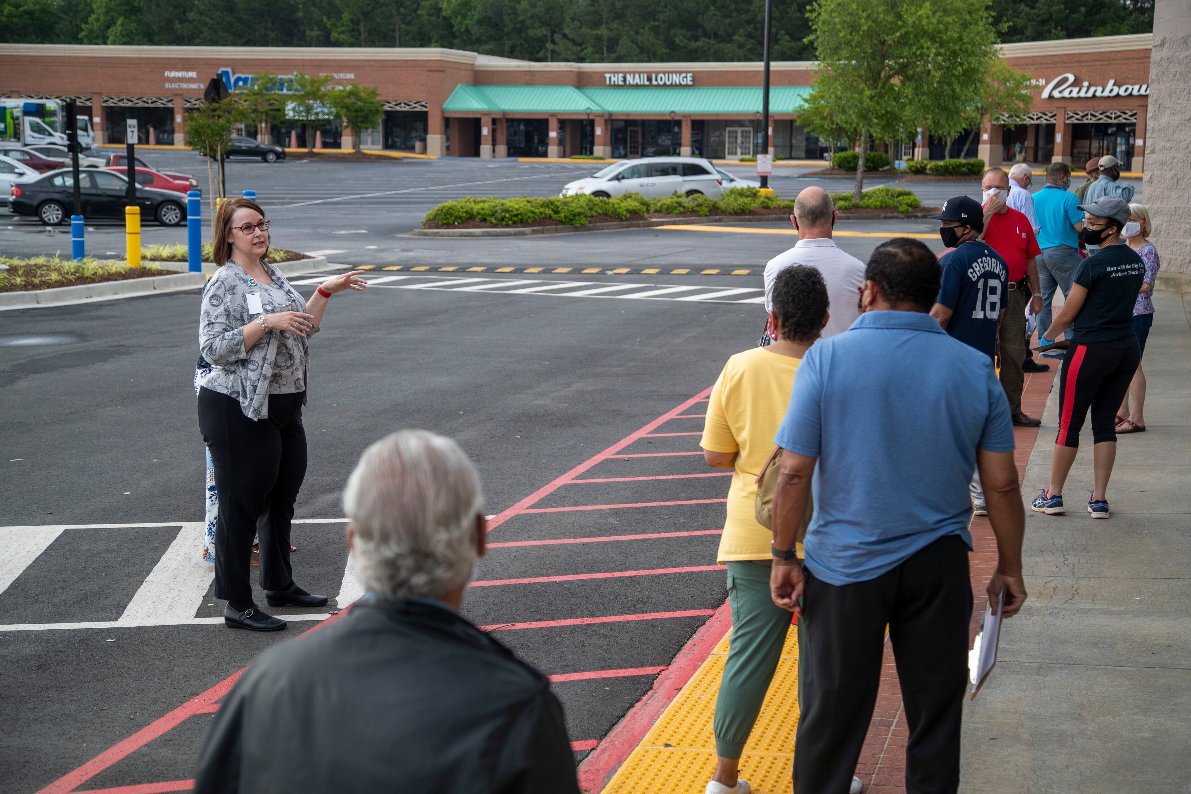 05/18/2020 - Lawrenceville, Georgia - Gwinnett County elections supervisor Kristi Royston (left) gives instructions to individuals waiting in line for early in-person voting at the Gwinnett County Voter Registration and Elections Office in Lawrenceville, Monday, May 18, 2020. Early voting began May 18 and will last three-weeks, ended June 5. Georgia's Election Day is Tuesday, June 9.(ALYSSA POINTER / ALYSSA.POINTER@AJC.COM)