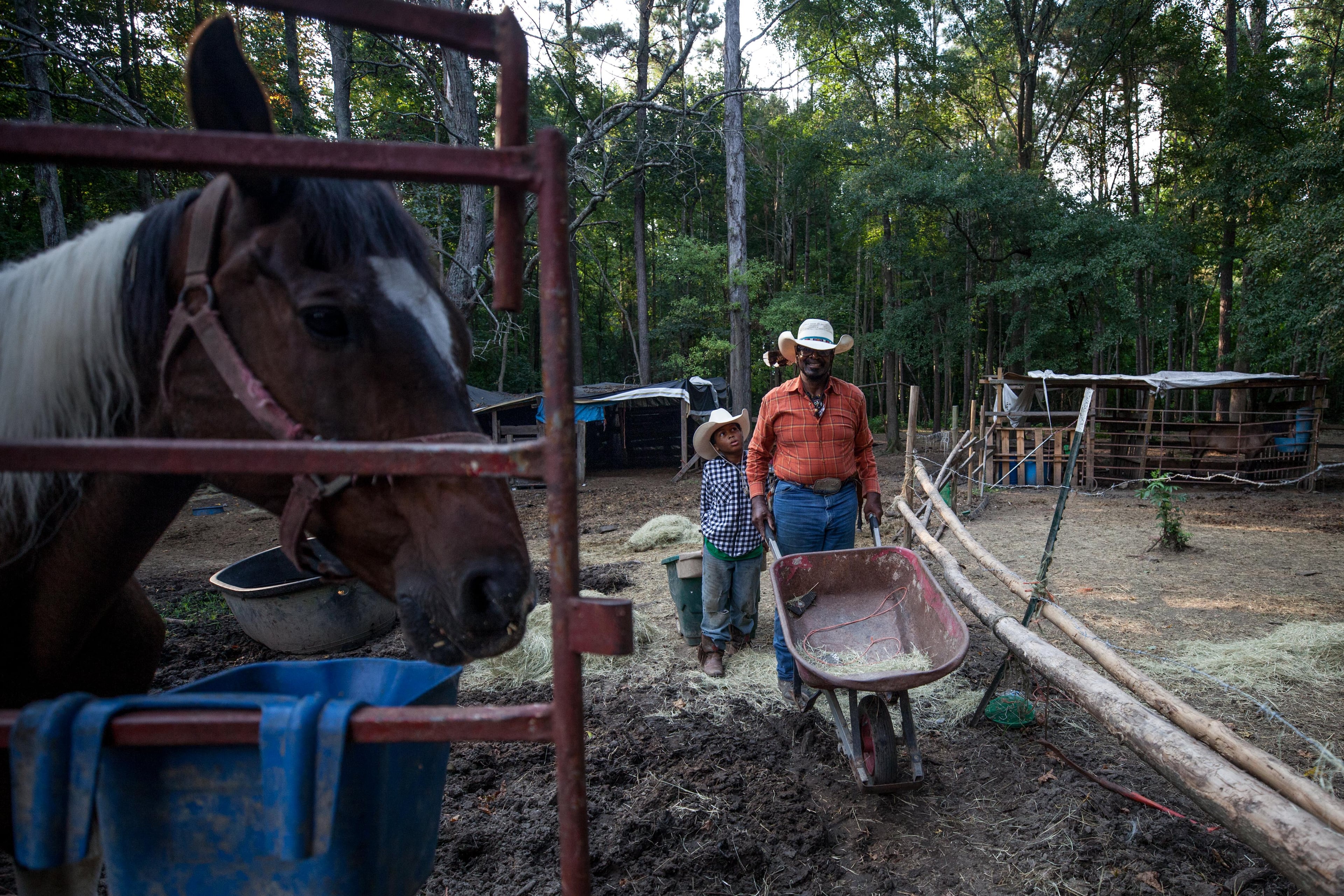 Billy Ray Thunder and his grandson Justin Brown, 11, feed the horses on his ranch off of Flat Shoals Parkway, Tuesday, July 30, 2019, in Union City. BRANDEN CAMP/SPECIAL