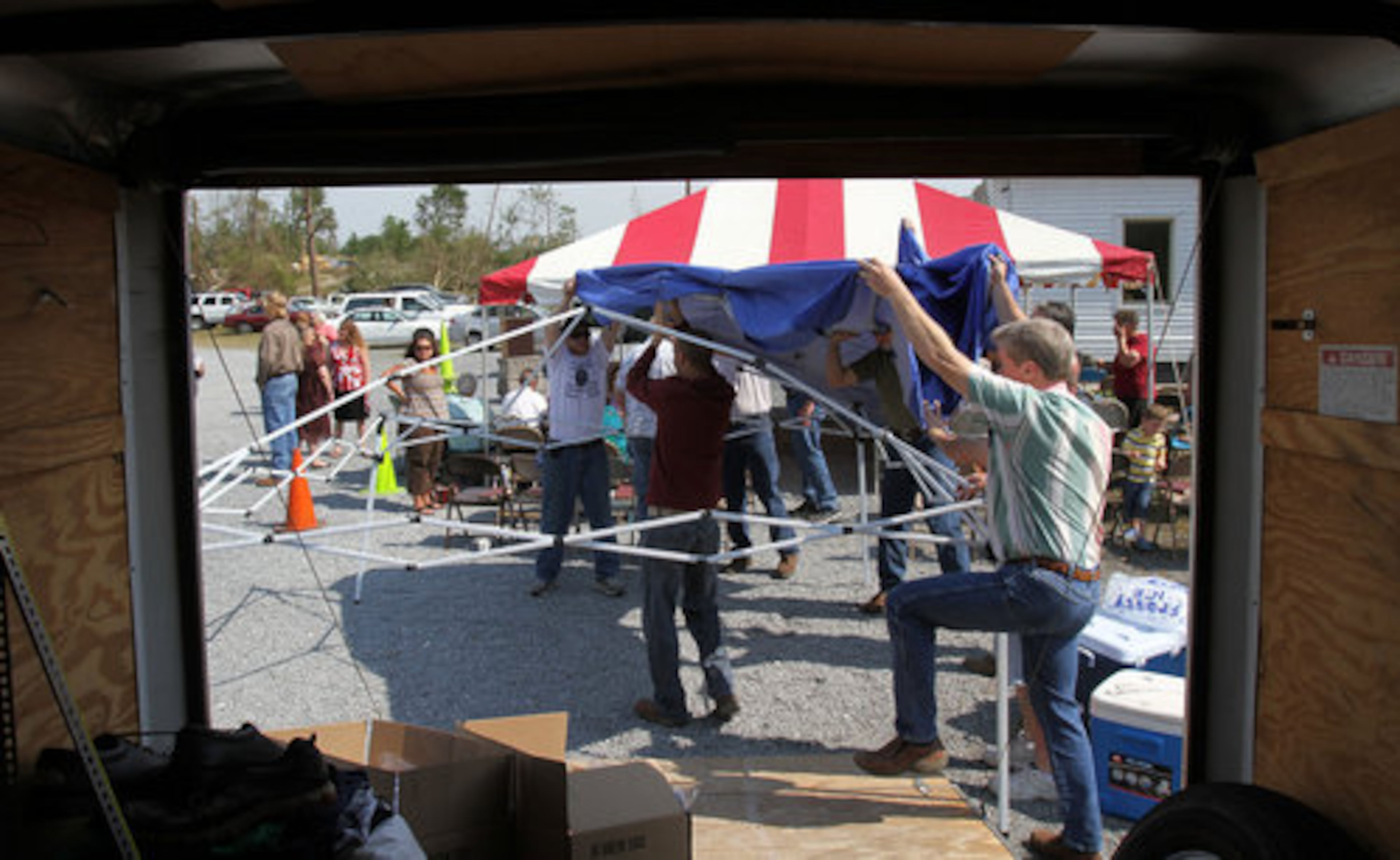 Volunteers help to raise a make shift tent for members of the Crowe Springs Baptist Church before their Sunday service at the church parking lot in Cartersville, May 1, 2011.