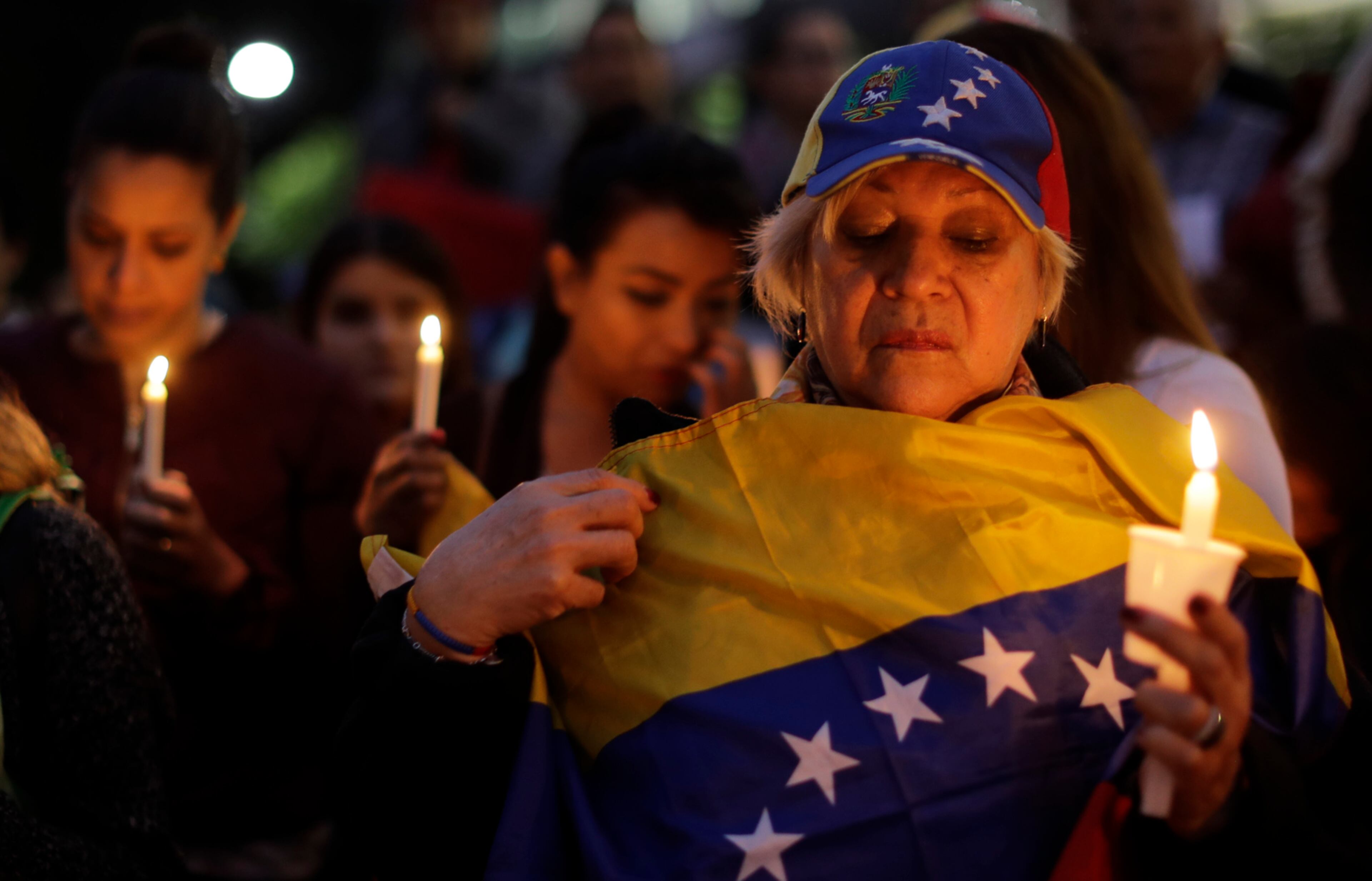 Protesters hold candles during a vigil in Buenos Aires, Argentina, Wednesday, April 19, 2017. Opponents of President Nicolas Maduro living in Argentina gathered in a square in the Argentine capital to show their support and demand changes in Venezuela. (AP Photo/Natacha Pisarenko)