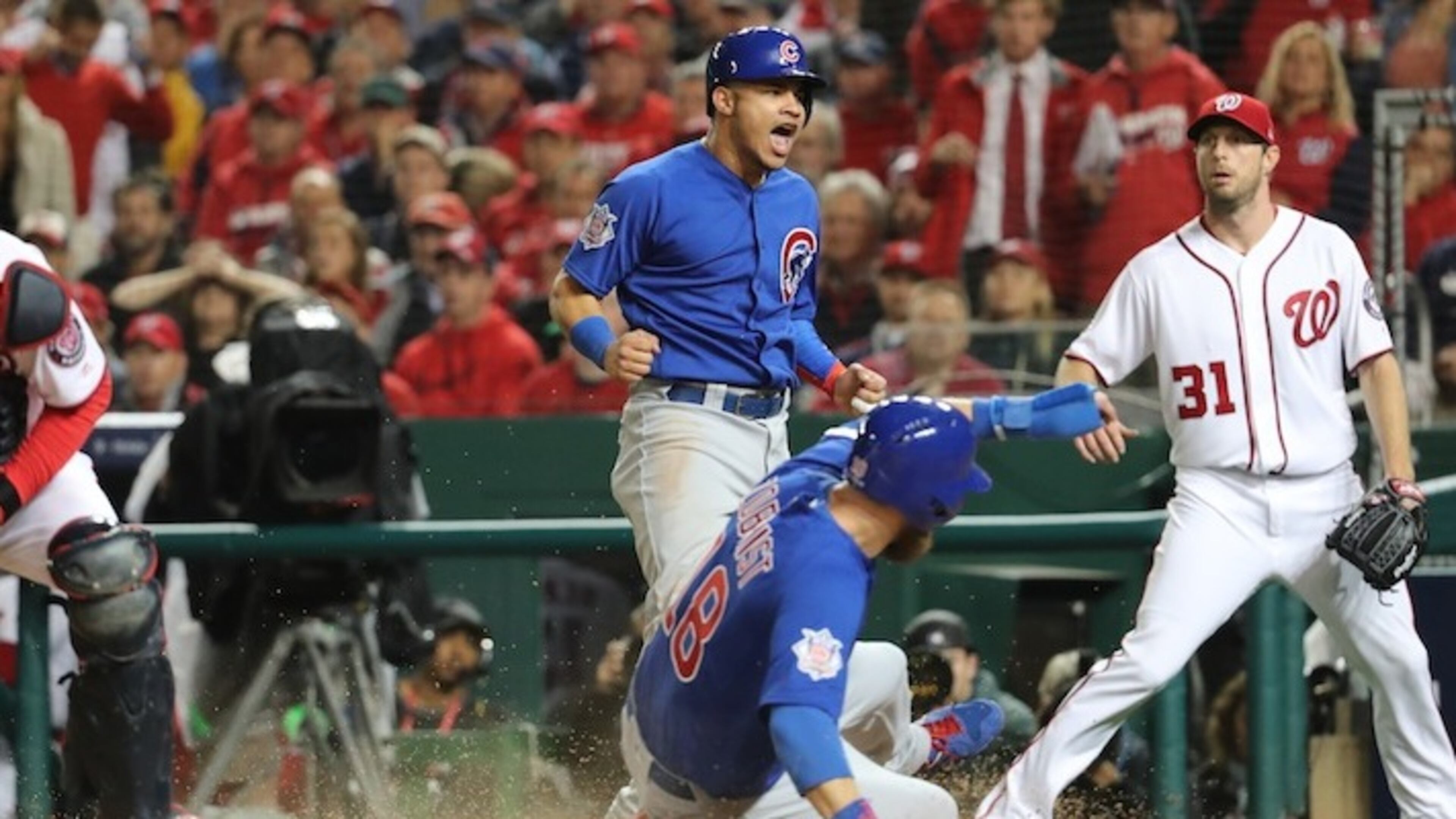 The Chicago Cubs' Ben Zobrist (18) scores behind teammate Willson Contreras on a two-run double by Addison Russell against the Washington Nationals in Game 5 of the National League Division Series on October 12, 2017, at Nationals Park in Washington, D.C. (Brian Cassella/Chicago Tribune/TNS)