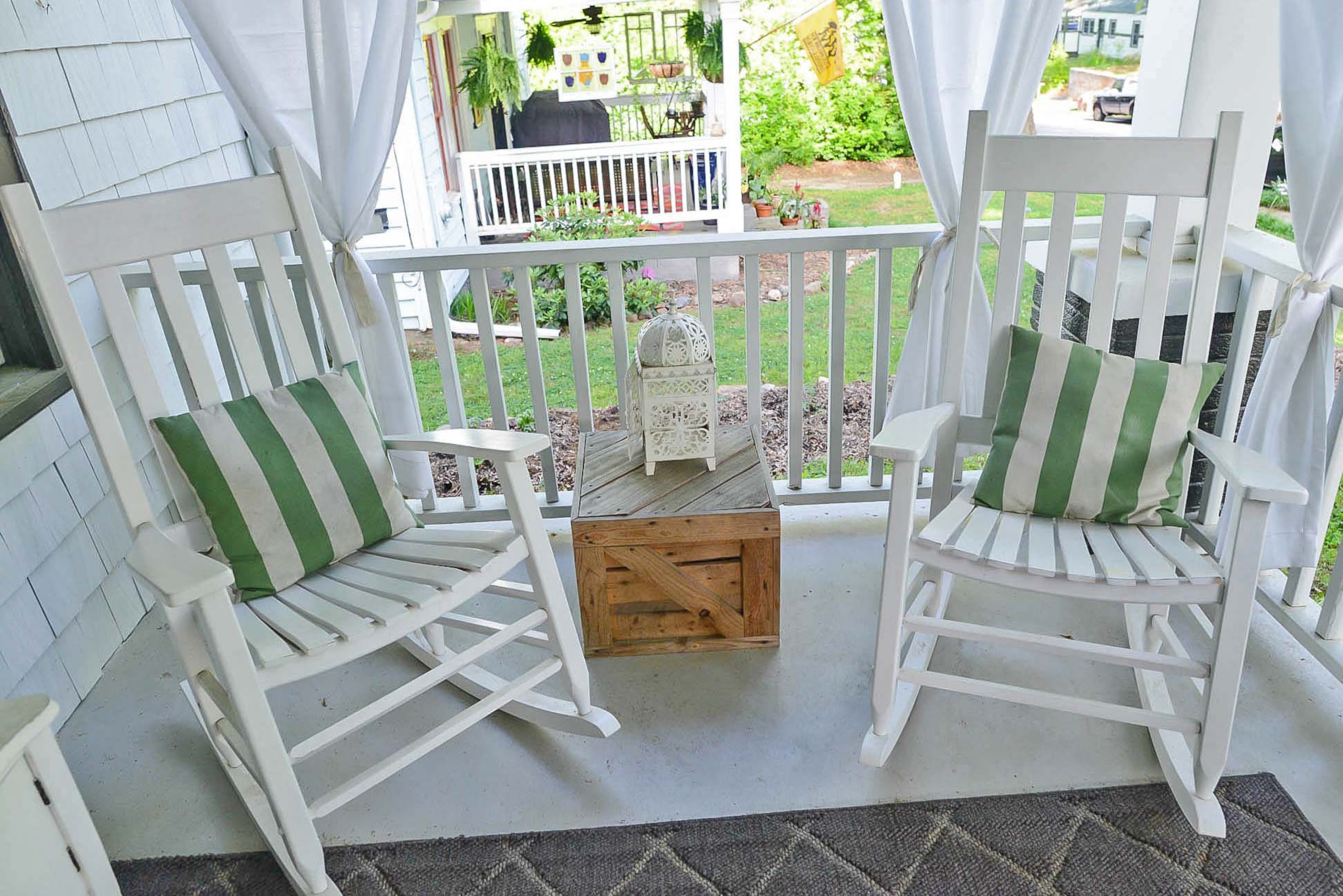 One seating area on the Kirkwood front porch has a pair of white rocking chairs around a table made by Andy McKeegan out of a pallet.