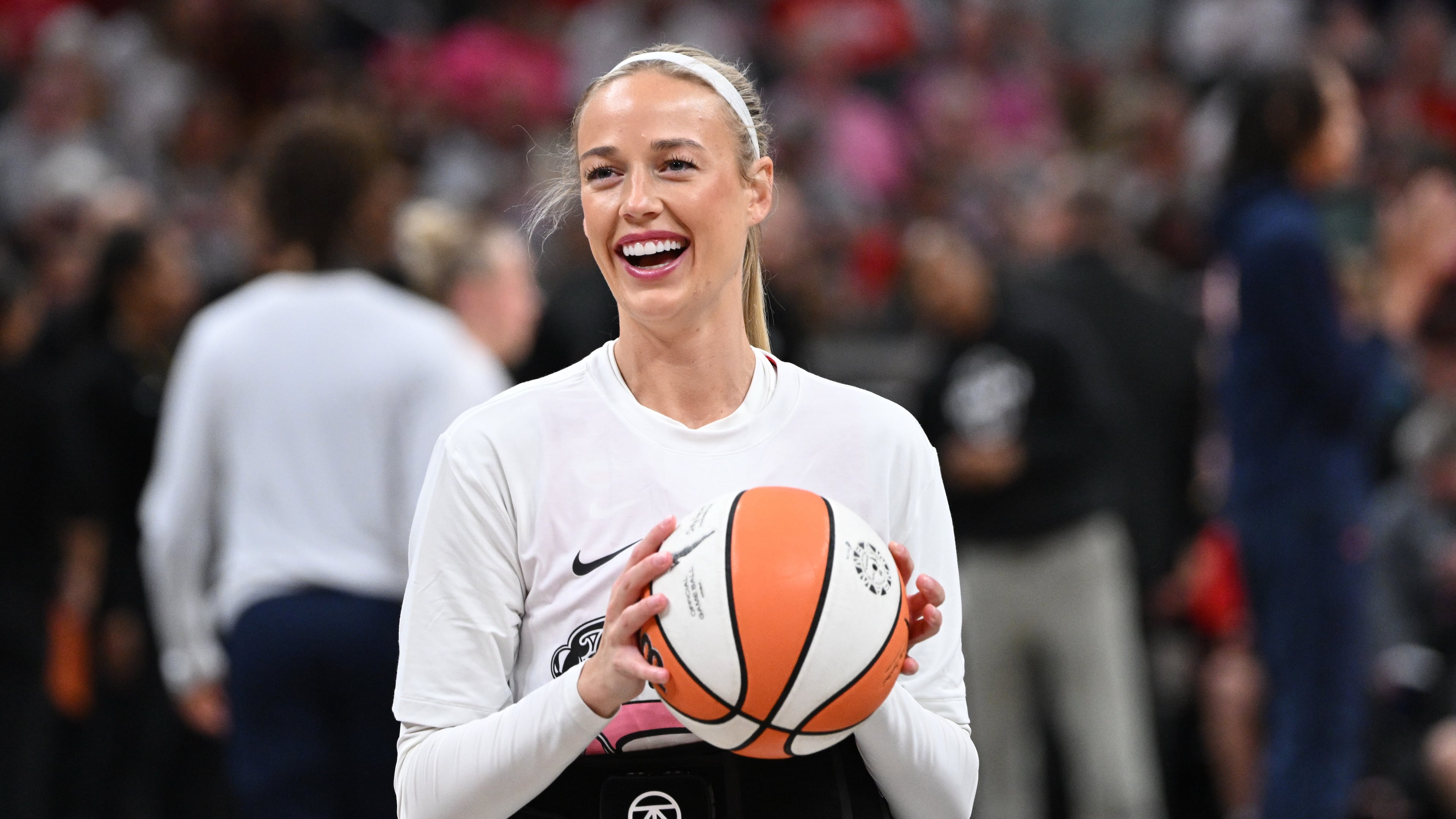 Indiana Fever guard Sophie Cunningham smiles while warming up before a WNBA basketball game against the Connecticut Sun, Friday, Aug. 28, 2026, in Indianapolis. (AP Photo/Marc Lebryk)