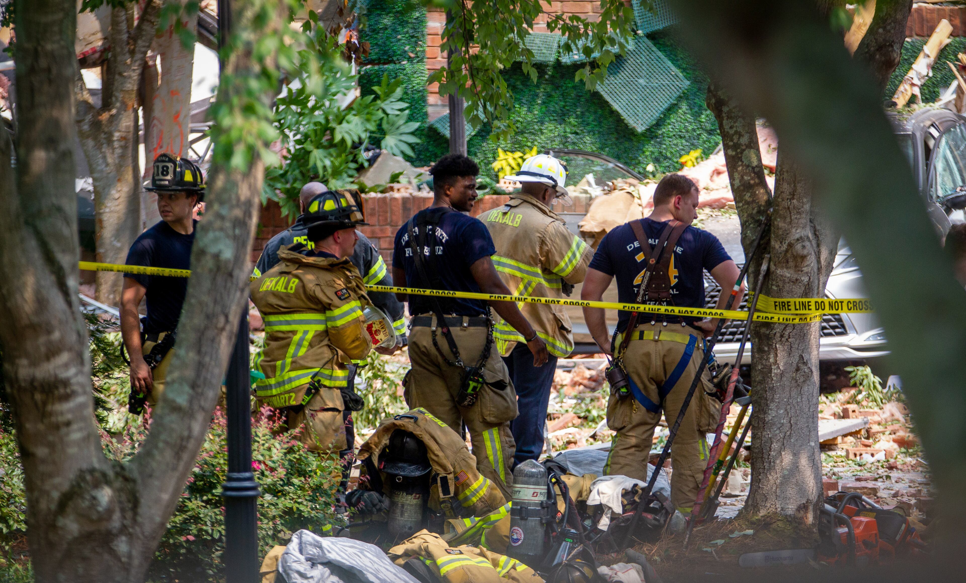 DeKalb County firefighters stand outside the Arrive Perimeter apartment complex after an explosion damaged the building Sunday, September 12, 2021. STEVE SCHAEFER FOR THE ATLANTA JOURNAL-CONSTITUTION