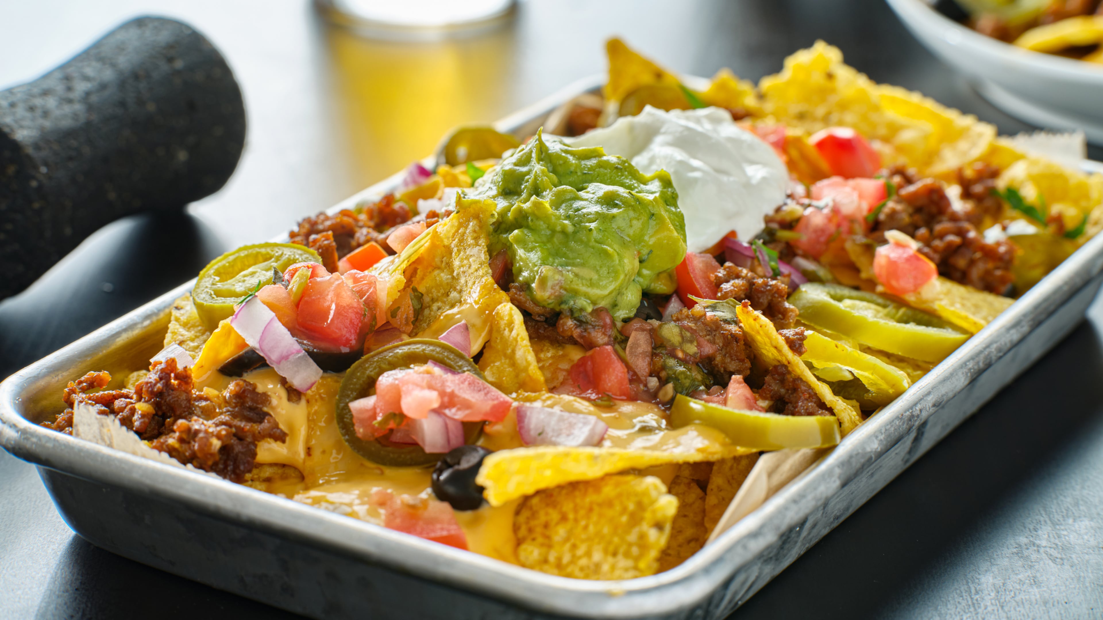 Tray of loaded nachos with beef and queso cheese close up
