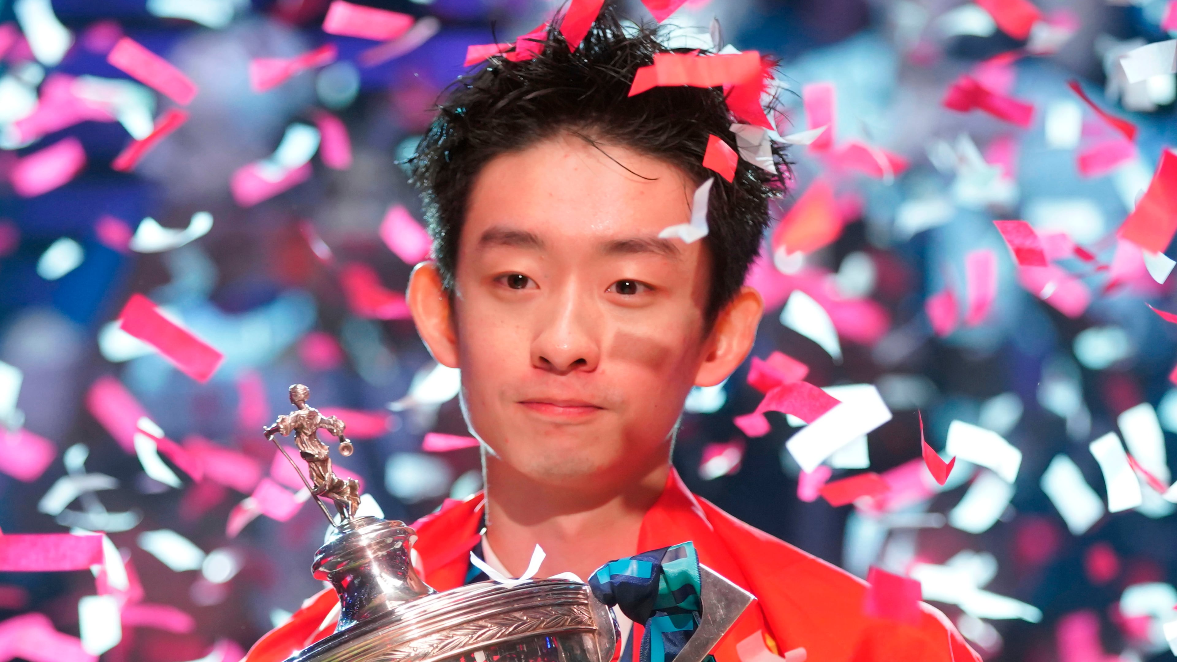 China's Wu Yize poses for the media with the trophy and wearing the Chinese national flag, after winning the World Snooker Championship defeating England's Shaun Murphy in Sheffield, England, Monday, May 4, 2026.(AP Photo/Ian Hodgson)