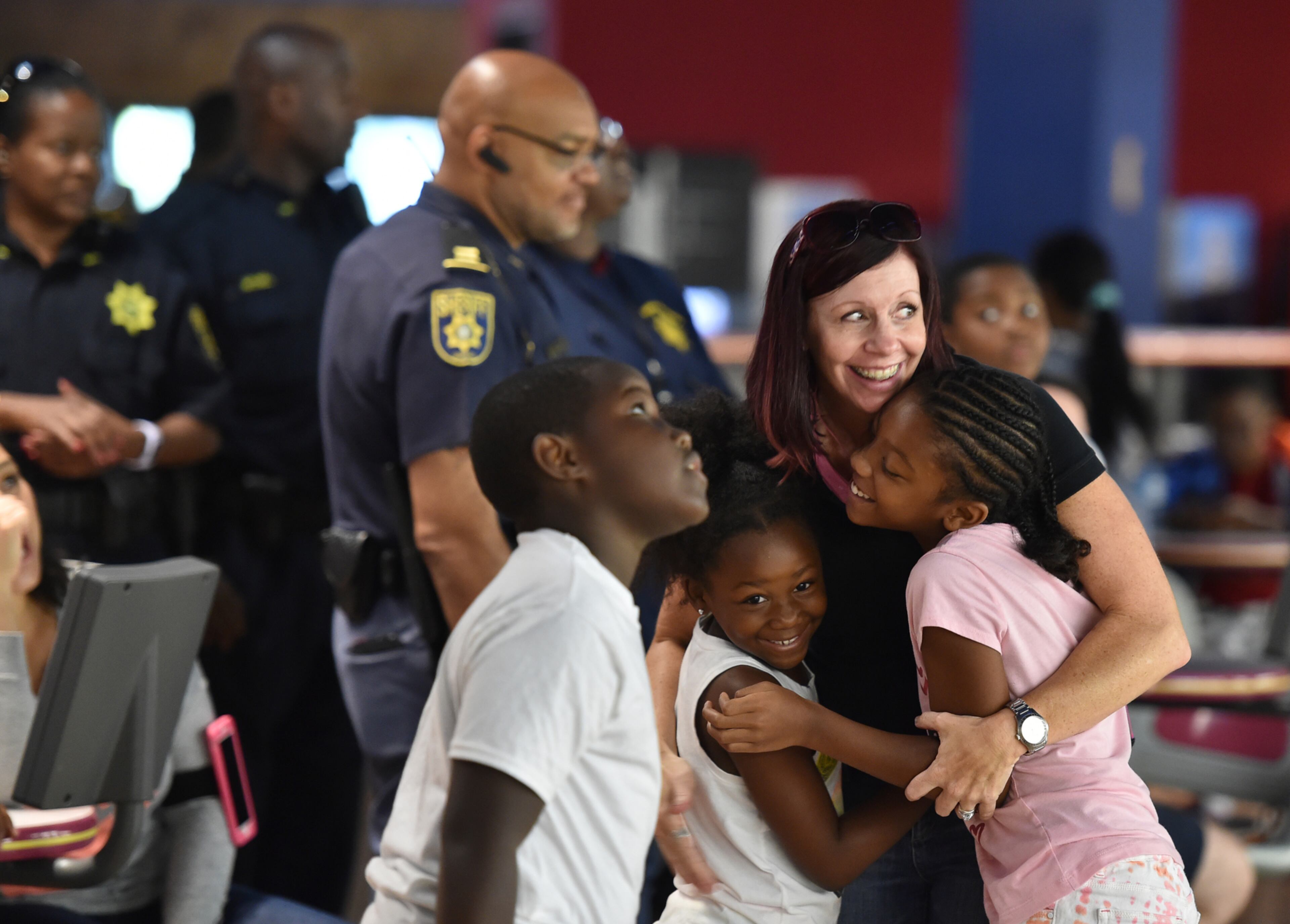 July 20, 2016 Atlanta: Brooke Wandel, an investigator for the DeKalb County District Attorney, celebrates a strike with Samantha Patterson, 8, right, and Courtney Davis,6, during 7th Annual Community Day with the Sheriff at Stars and Strikes Family Entertainment Center in Stone Mountain. The event, founded by Tom Walker, Sr. with Save our Youth, is a way for kids 13-17 to interact with police officers in a positive way. "Our goal each year has been to help school children lean to trust and respect law enforcement officials by meeting them one-on-one in a fun, friendly environment" said DeKalb County Sheriff Jeffrey Mann. Law enforcement officers from the DeKalb County Police Department also took part in the event. More than 100 kids were treated to bowling, pizza and back to school supplies. BRANT SANDERLIN/BSANDERLIN@AJC.COM