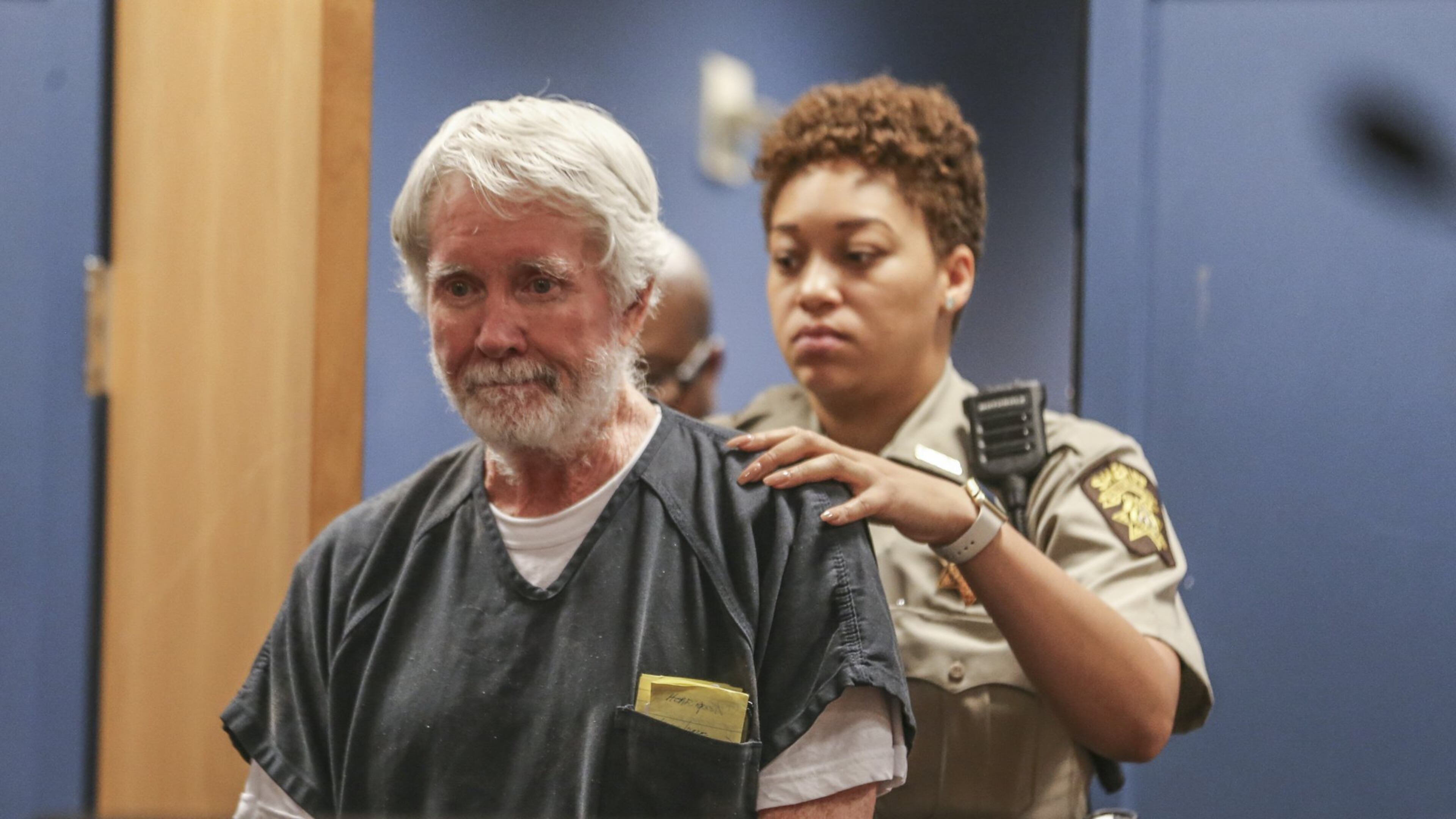 Fulton County deputy, K. Jackson brings Claud “Tex” McIver into the courtroom during a recent appearance. JOHN SPINK/JSPINK@AJC.COM.